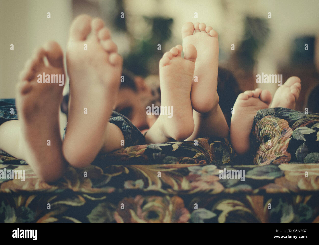 Close up of feet of children on sofa Stock Photo