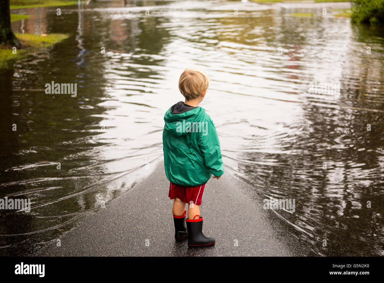 Caucasian boy wearing puddles near flood Stock Photo