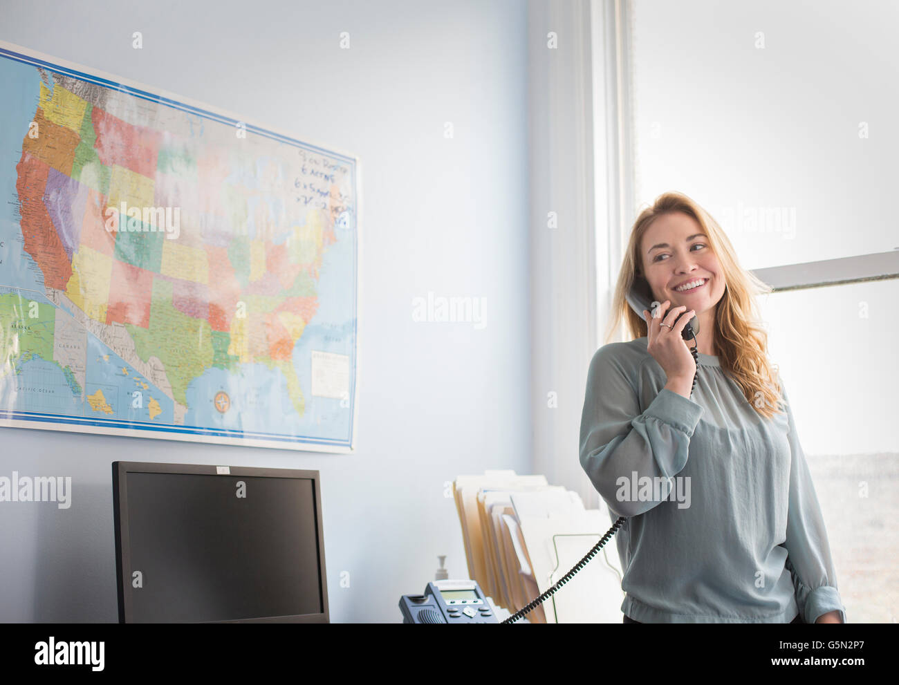 Caucasian businesswoman talking on telephone in office Stock Photo