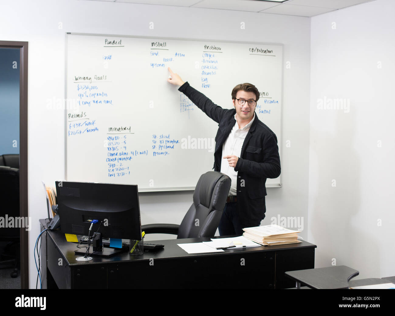 Caucasian businessman pointing to whiteboard in office Stock Photo
