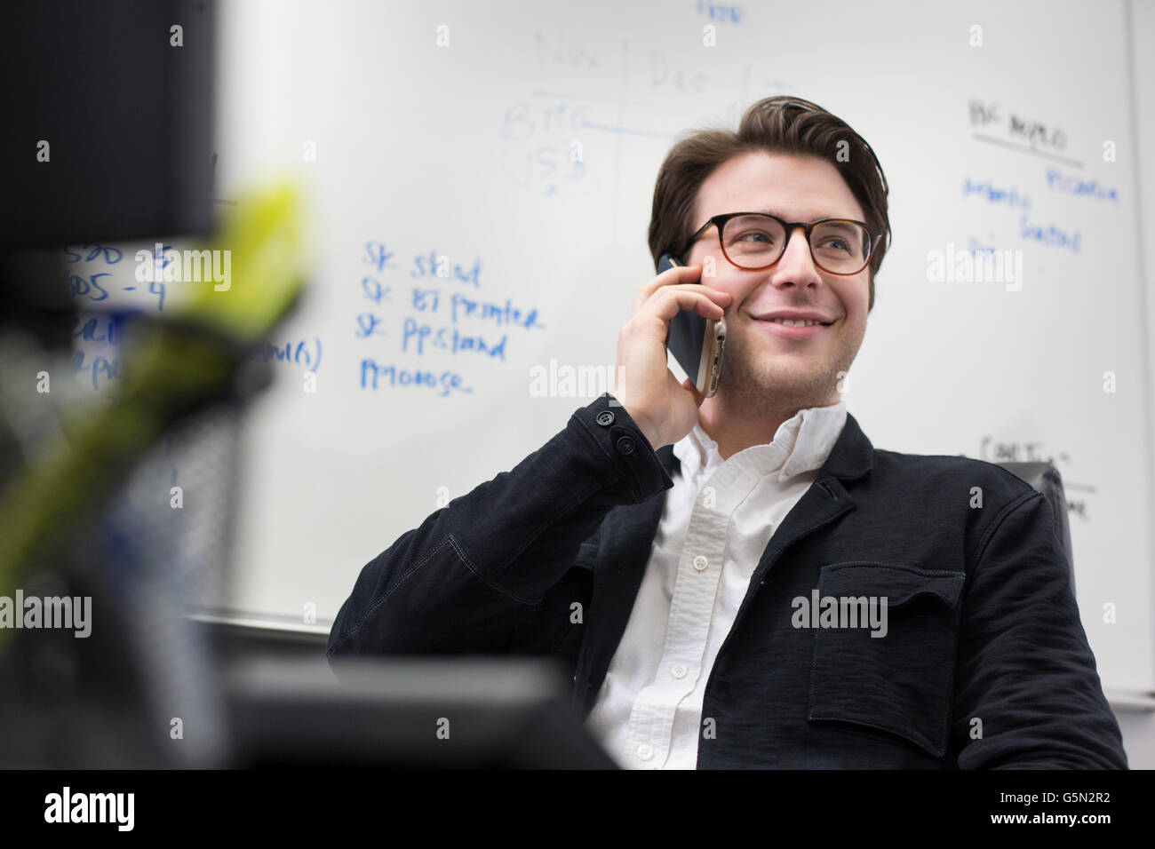 Caucasian businessman talking on cell phone in office Stock Photo