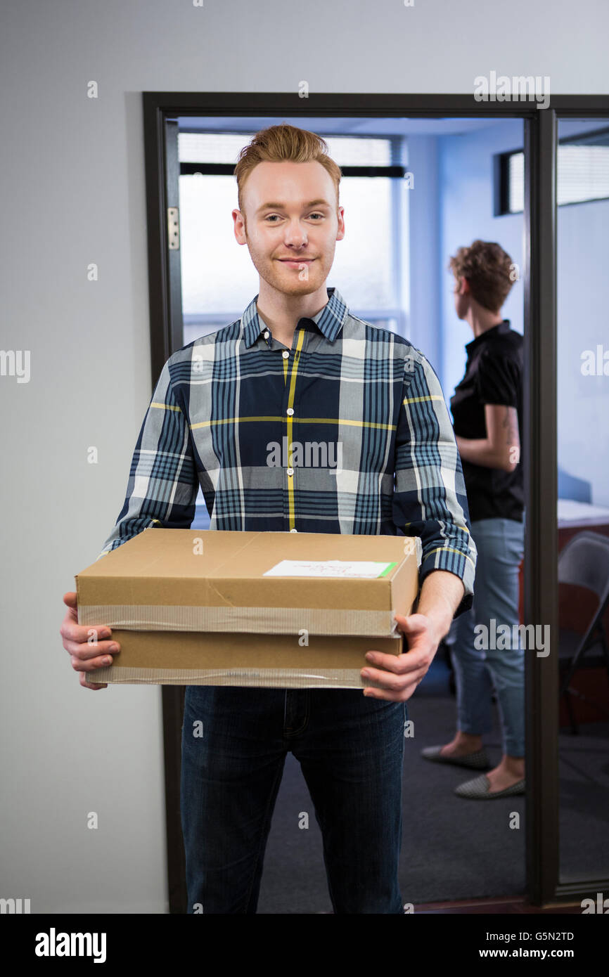 Caucasian businessman carrying packages in office Stock Photo