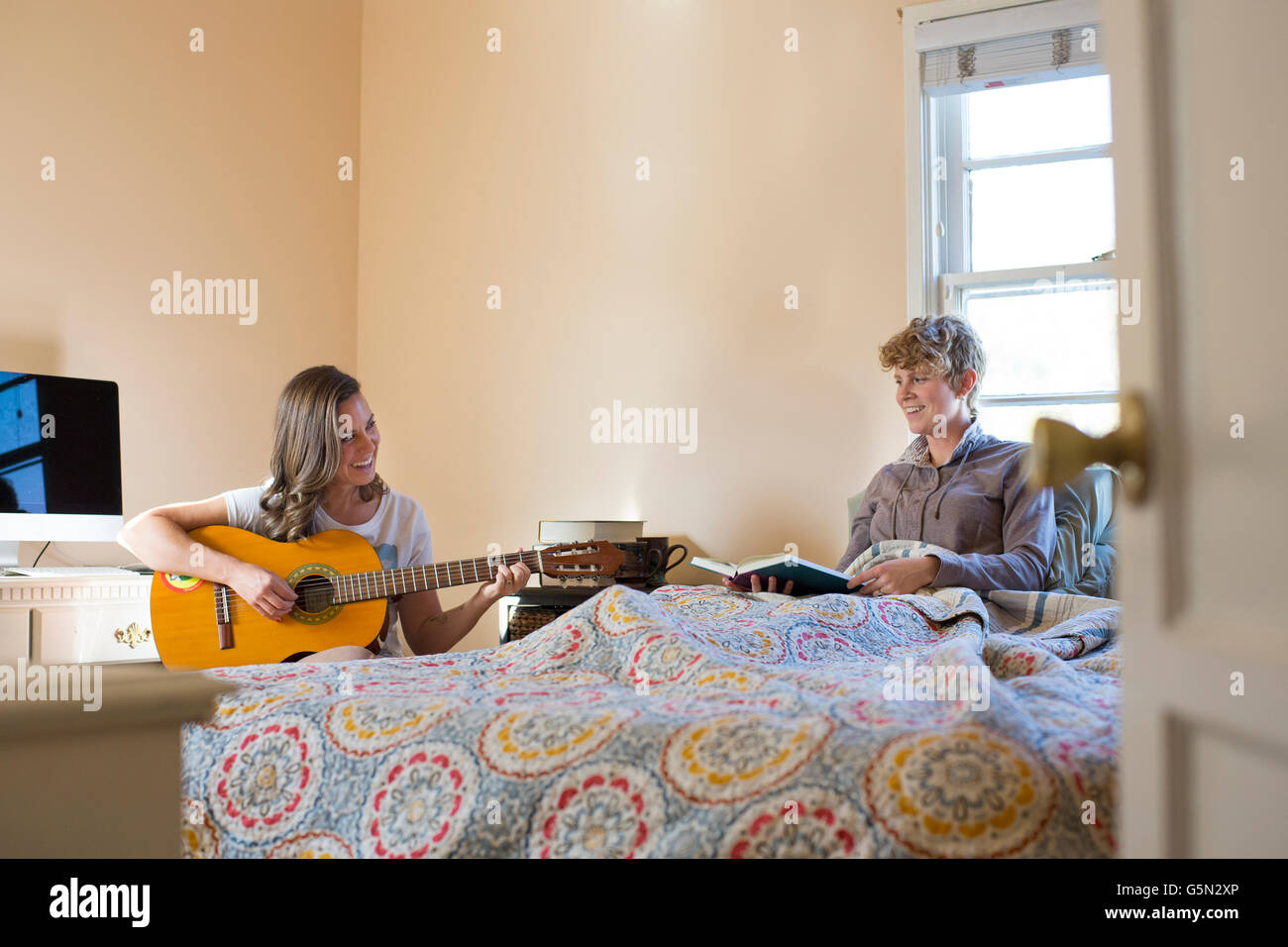 Caucasian lesbian couple relaxing in bedroom Stock Photo