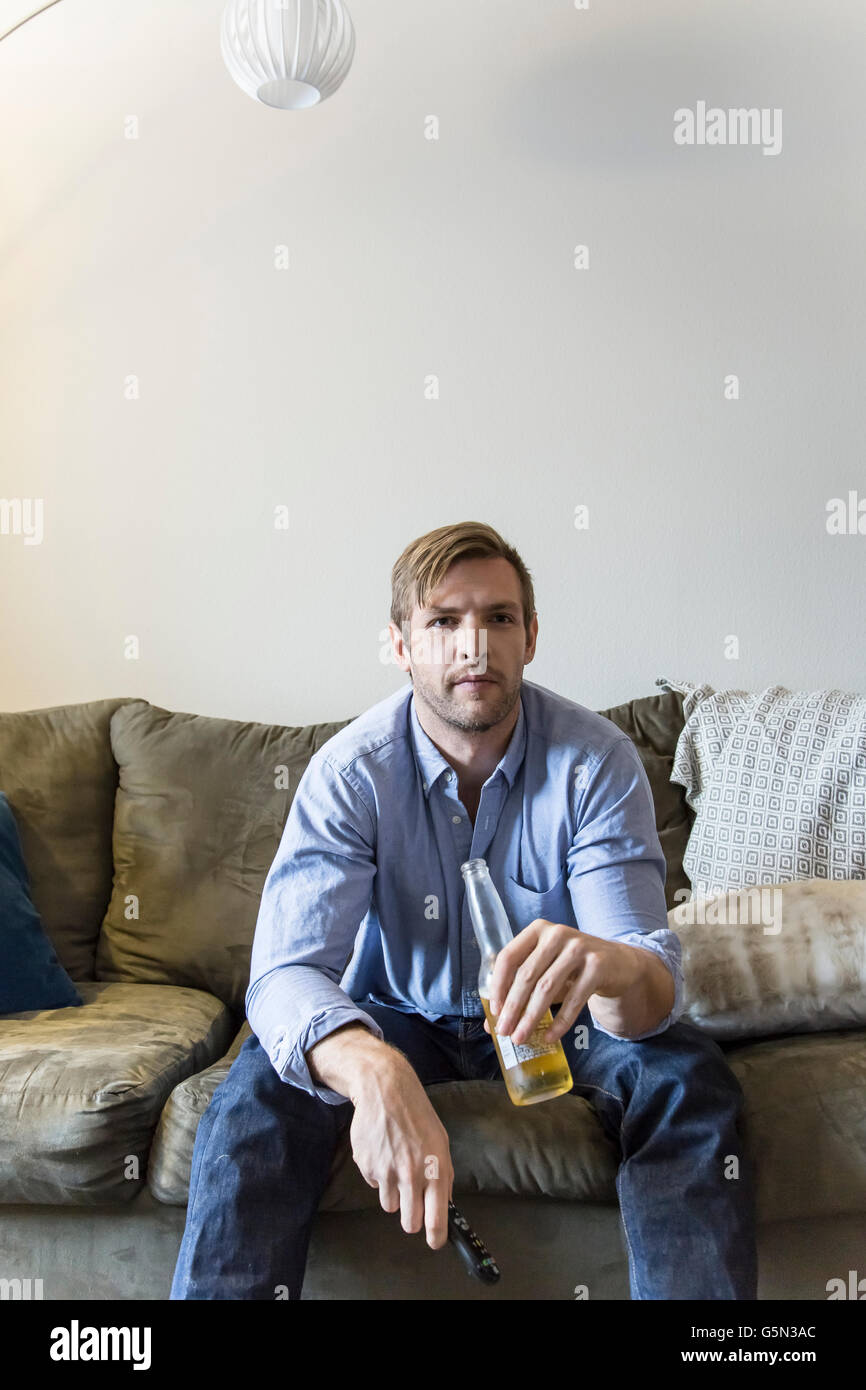 Man drinking beer on sofa Stock Photo Alamy