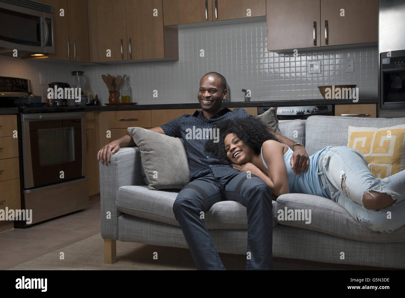 African American couple relaxing on sofa Stock Photo - Alamy