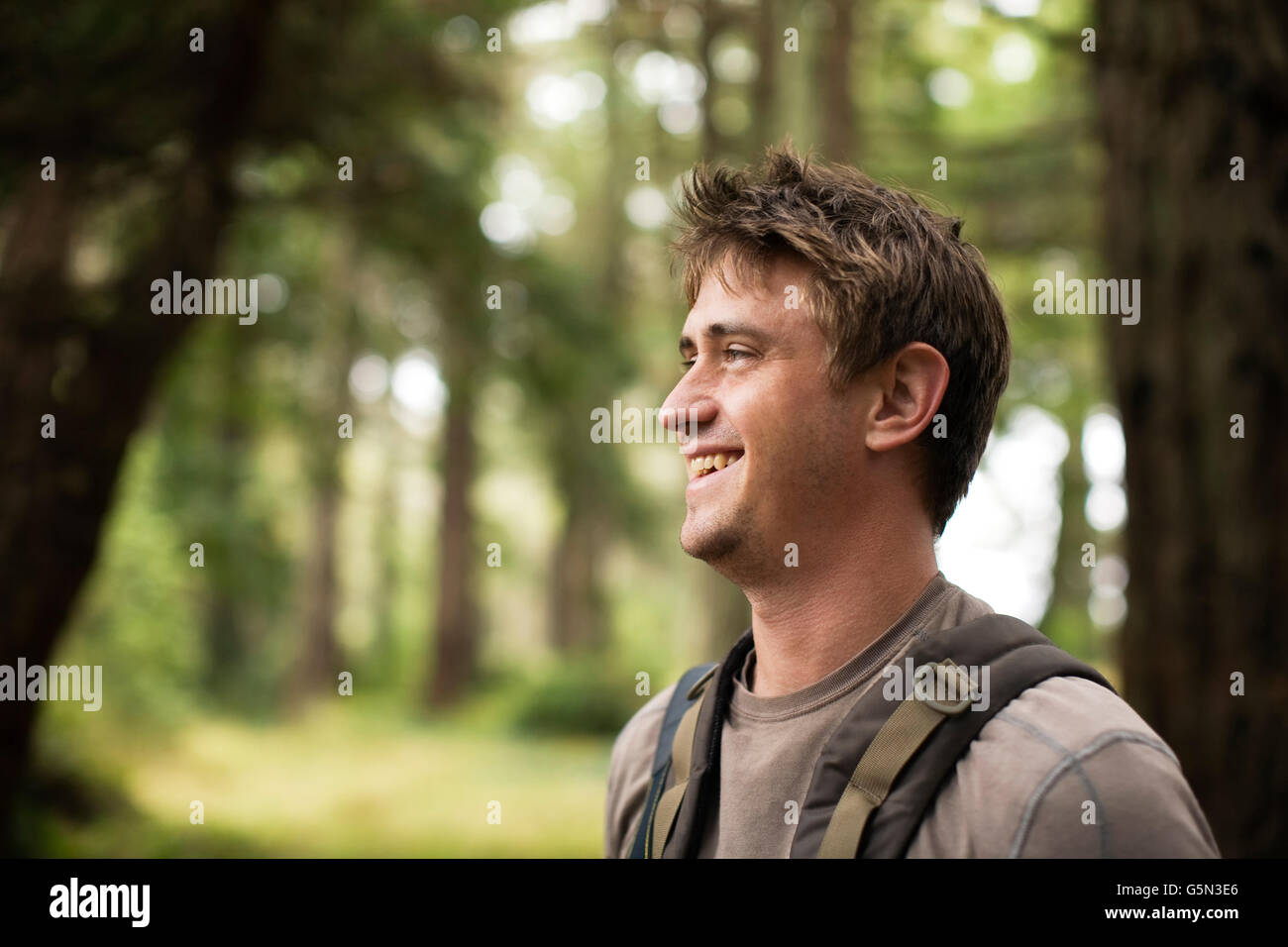 Caucasian man smiling in forest Stock Photo