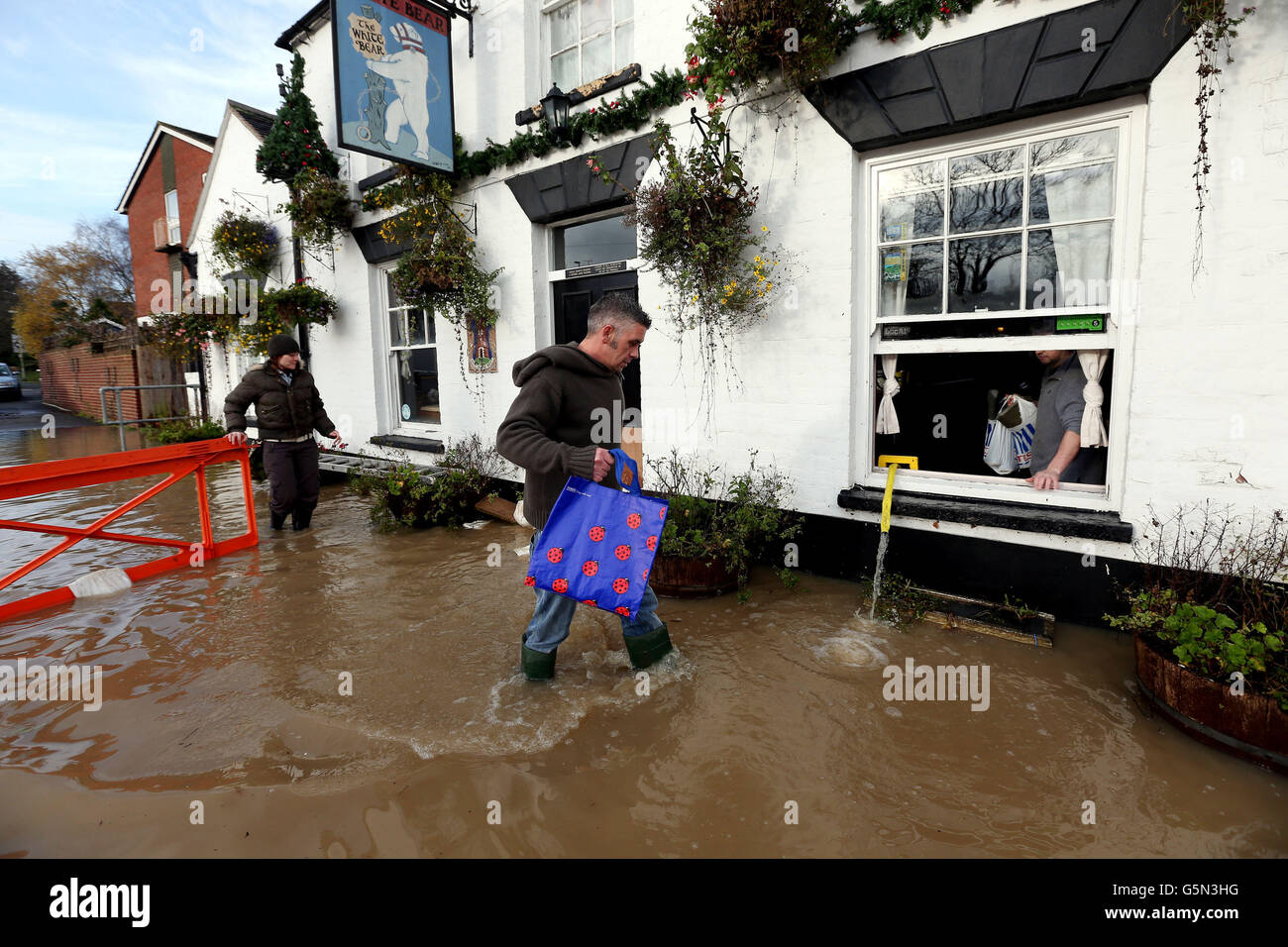 Friends bring supplies to David Boazman at the White Bear Pub in Tewkesbury, as he pumps flood water out of the pub. Stock Photo