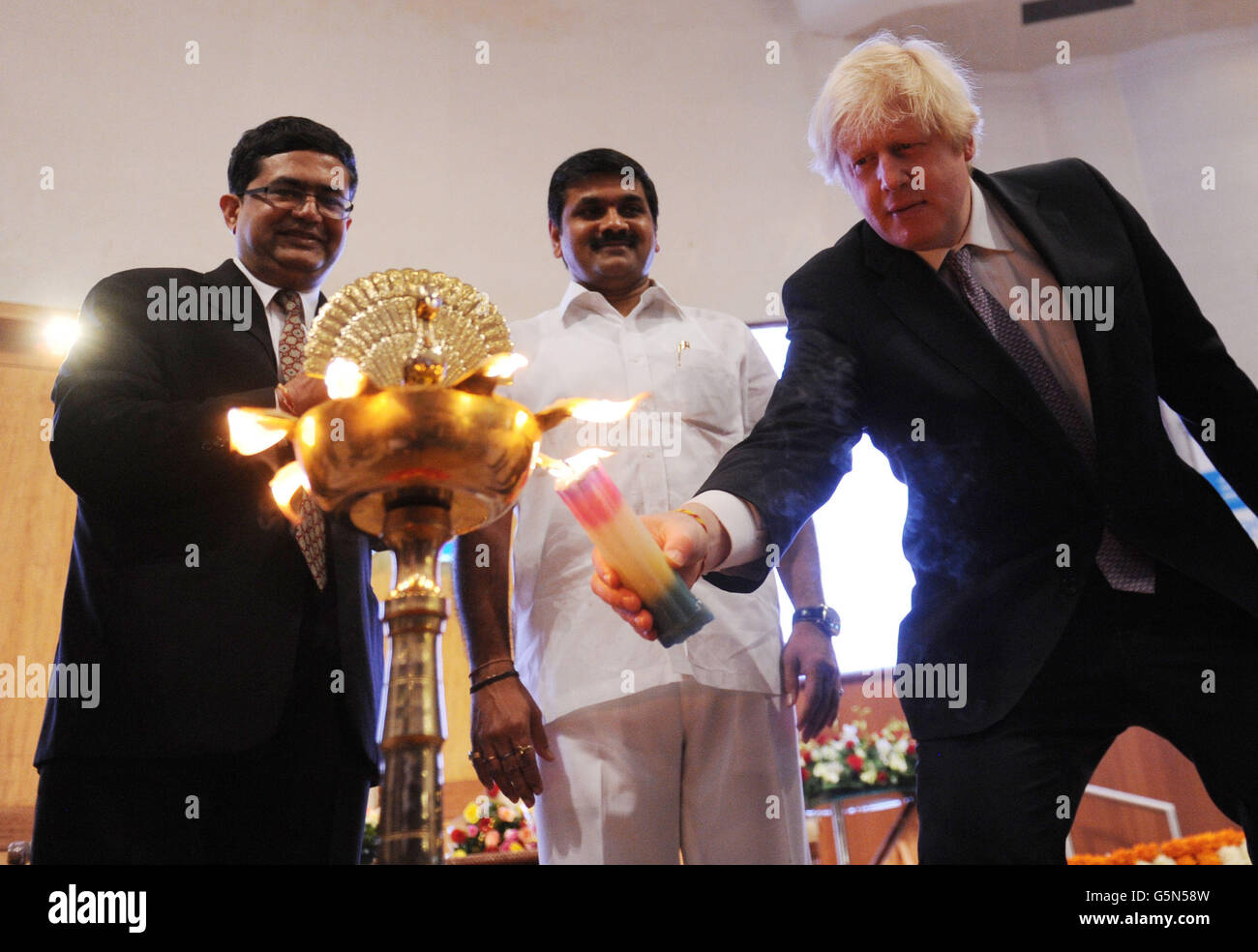 London mayor Boris Johnson officially opens the days trading at the Bombay Stock Exchange, in Mumbai, as Ashish Chauhan, CEO of the Bombay Stock Exchange (left) and Sachin Ahir, Minister for Housing and the Environment (centre) look on, as part of a week long tour of India where he is trying to persuade Indian businesses to invest in London. Stock Photo