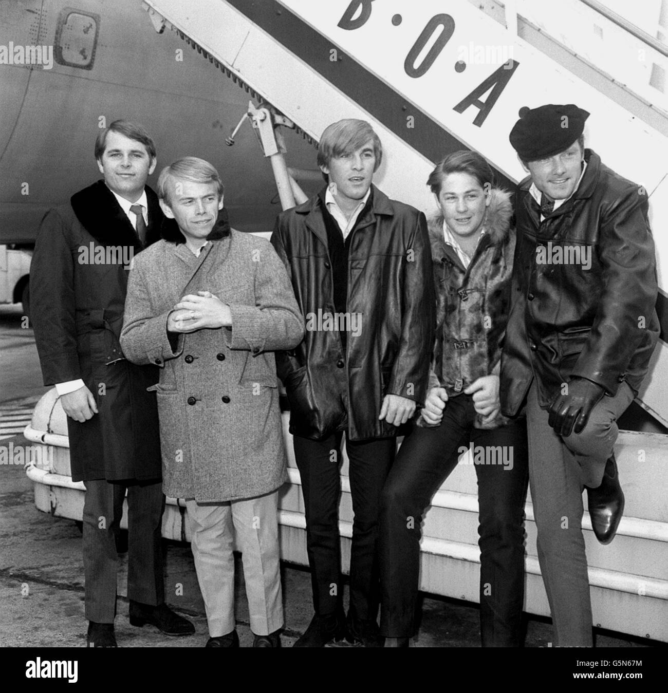 Dressed for a British November rather than some sunny shore are The Beach Boys, the American pop singing group with the 'surfing' sound,they arrived at London Airport from New York by BOAC liner. (l-r) Carl Wilson, Al Jardine, Dennis Wilson, Brian Wilson and Mike Love Stock Photo