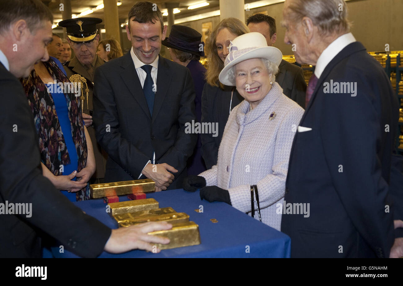 Queen Elizabeth II and the Duke of Edingburh looks at gold bars during their visit to the Bank of England in central London. Stock Photo
