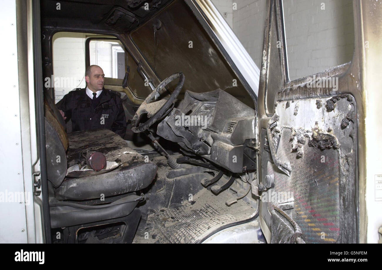 A police officers at Hayes police station examines a van used by robbers who attacked a BA security van in a secure airside cargo loading area near Heathrow Airport's Terminal 4, and who escaped with 4.6 million. * The vehicle was subsequently found abandoned and burning two miles away in a residential area in Feltham, west London. Government ministers responsible for aviation security have ordered a report on how thieves managed to gain access to the airport's restricted zone during a period of heightened security in the wake of events on September 11. Stock Photo