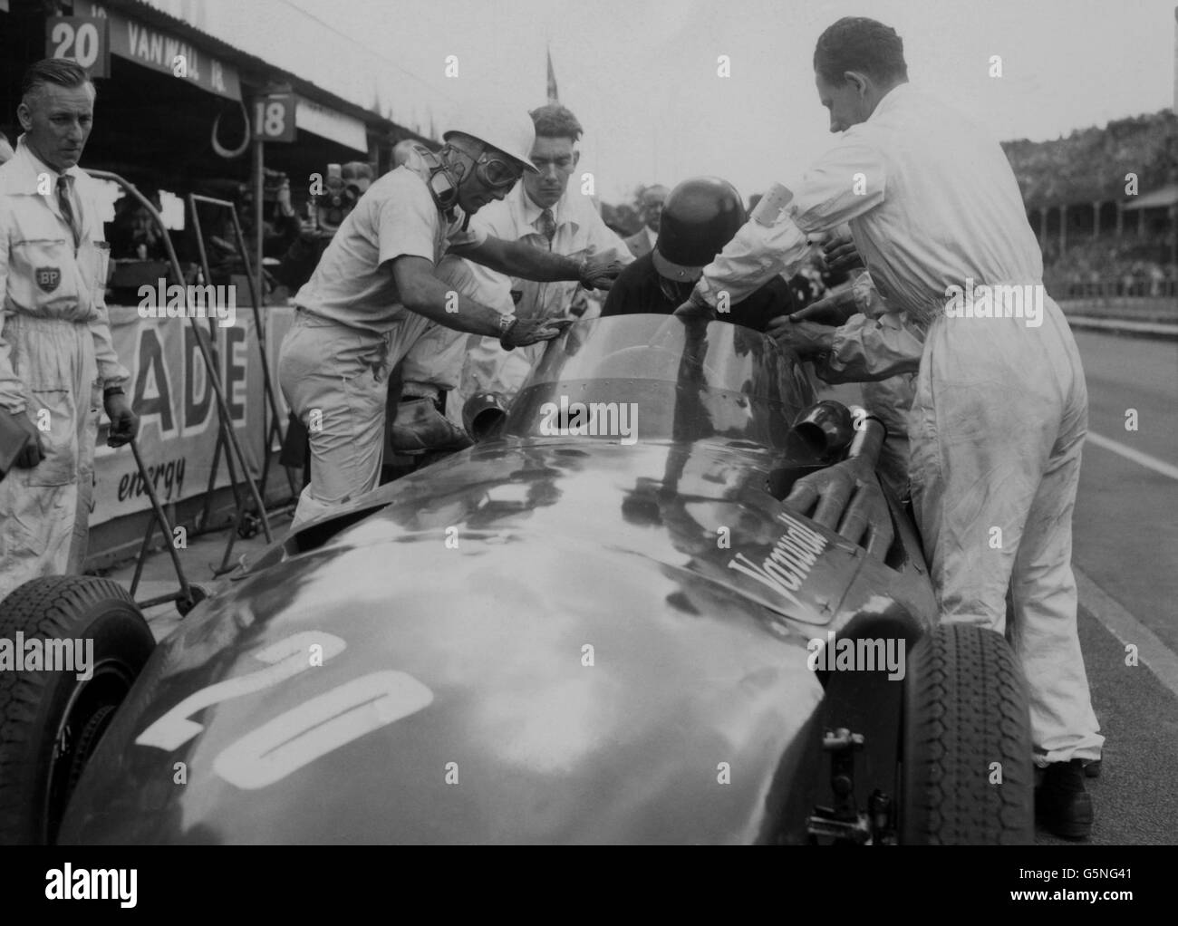 Stirling Moss climbs in to the driving seat of Tony Brooks' Vanwall after his own had developed problems during the Grand Prix d'Europe race at Aintree, Liverpool. Moss went on to achieve the first all-British victory in a major classic since 1923. Stock Photo
