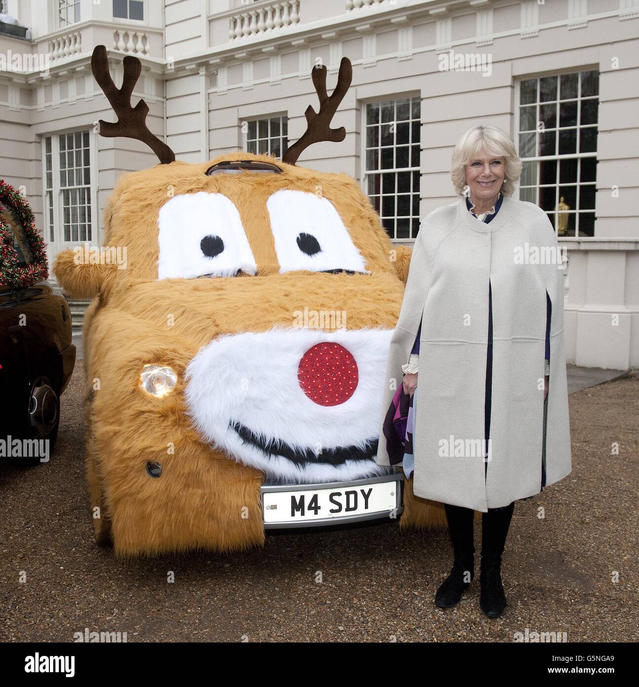 The Duchess of Cornwall stands in front of a decorated taxi as she invited a group of youngsters to Clarence House, London, to help decorate her Christmas tree. PRESS ASSOCIATION Photo. Picture date: Wednesday December 12, 2012. Camilla got into the festive spirit and was ably assisted by children with life-shortening diseases. The eight youngsters, who receive support from the Helen & Douglas House Hospice, based in Oxford, not only placed baubles on the tree but also enjoyed a bangers-and-mash lunch with the Duchess. Camilla is patron of the hospice, which provides respite and end- of-life Stock Photo
