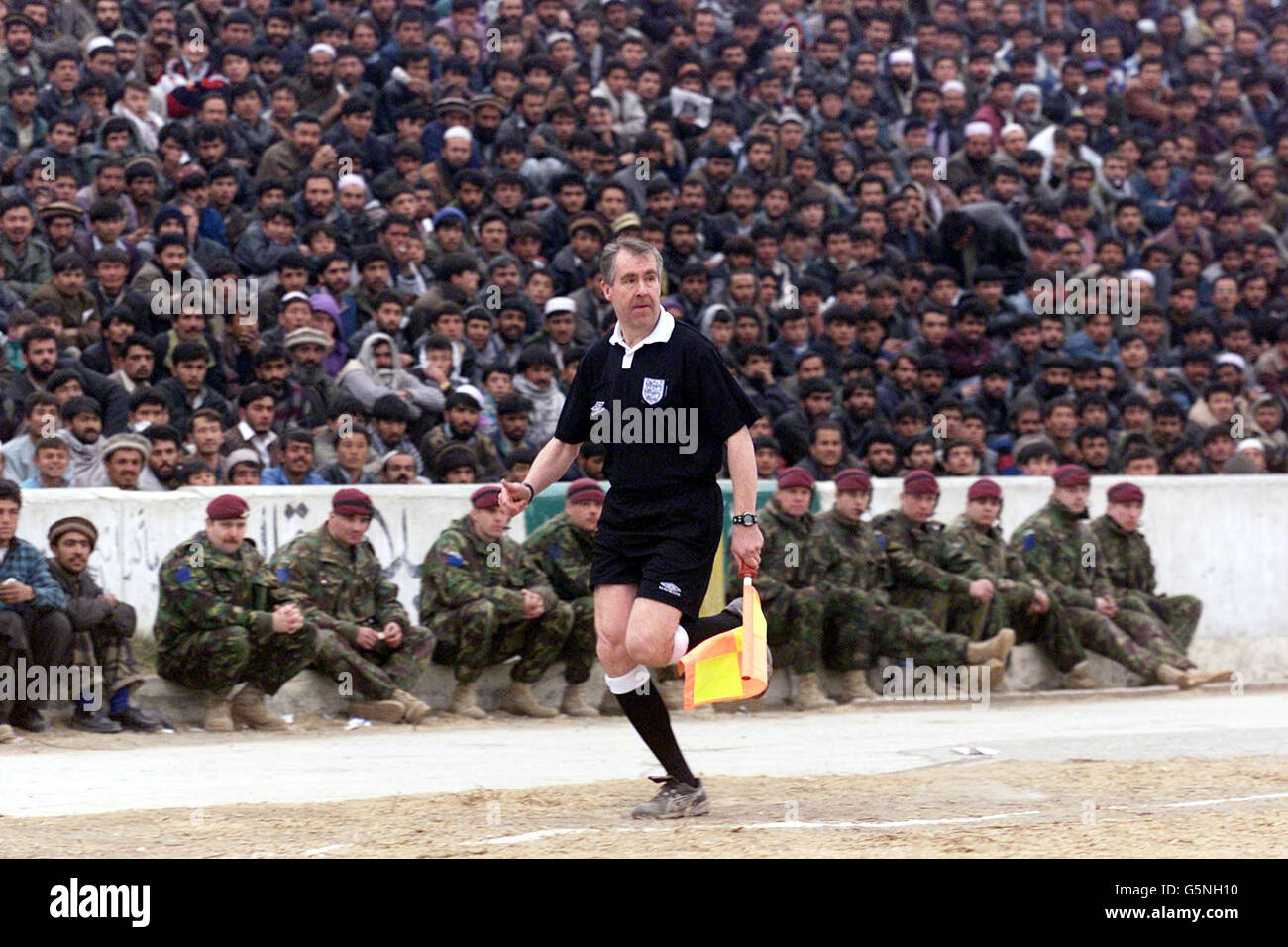 Assistant referee Andy Martin in action during a soccer match at the Olympic Stadium in Kabul, Afghanistan between ISAF (the International Security Assistance Force) and Kabul FC (in blue). The game was organised by the Football Association, the MoD and Barclaycard the new sponsors the Premiership. Lawrie McMenemy and former Tottenham Hotspurs player Gary Mabbutt have spent two days in the war torn country coaching both teams. The ISAF side includes soldiers from Great Britain, Italy, Germany and Holland and played in the Olympic Stadium more infamous for the executions held there by the Stock Photo