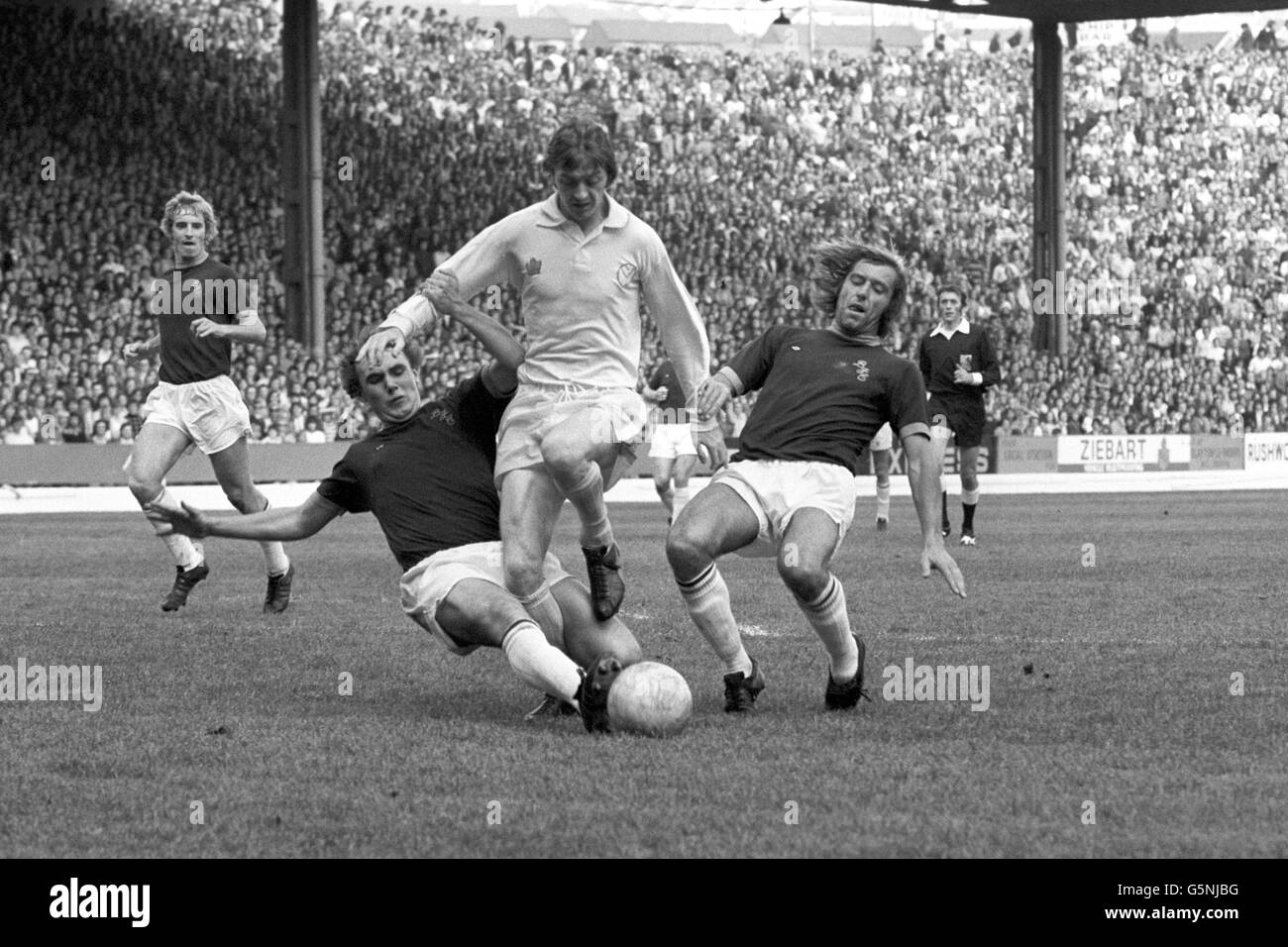 Allan Clarke, the Leeds United forward, has it all his own way for the moment, as he creates havoc with Burnley, whose defender Keith Newton, is on the right. Burnley won the match 2-1. Stock Photo