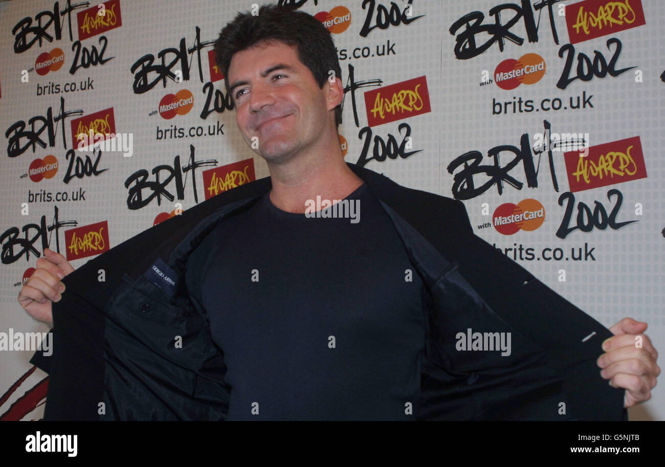 Presenter at the annual Brit awards Simon Cowell shows off his jacket to the photographers backstage at the awsrds in London. Cowell one of the judges in the recent 'Pop Idol' series on television is reported to be lined up as a judge for a version to be shown in the United States. Stock Photo