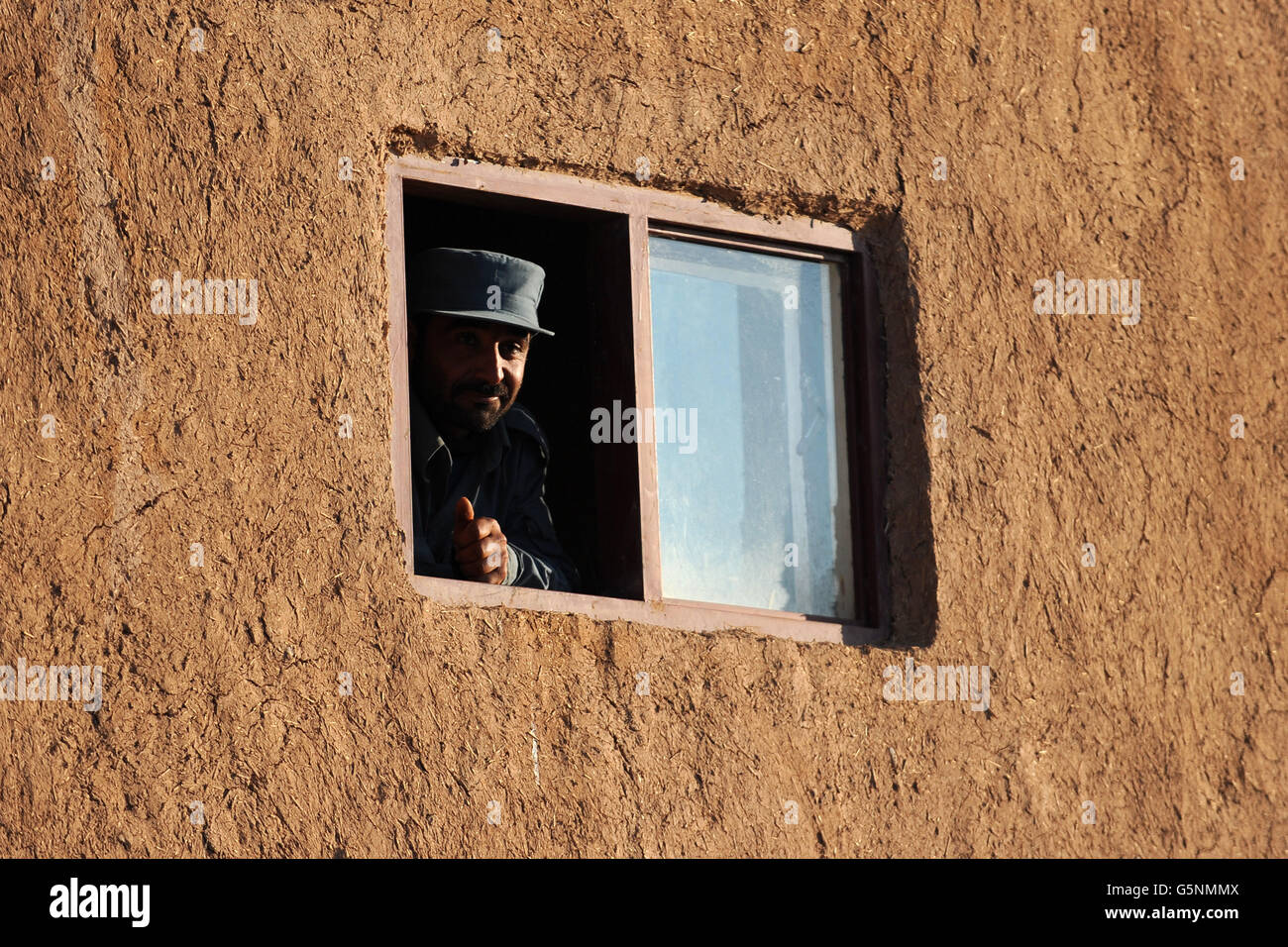 A member of the Afghan National police (ANP) looks out from checkpoint Chara-He, Helmand Province, Afghanistan Stock Photo