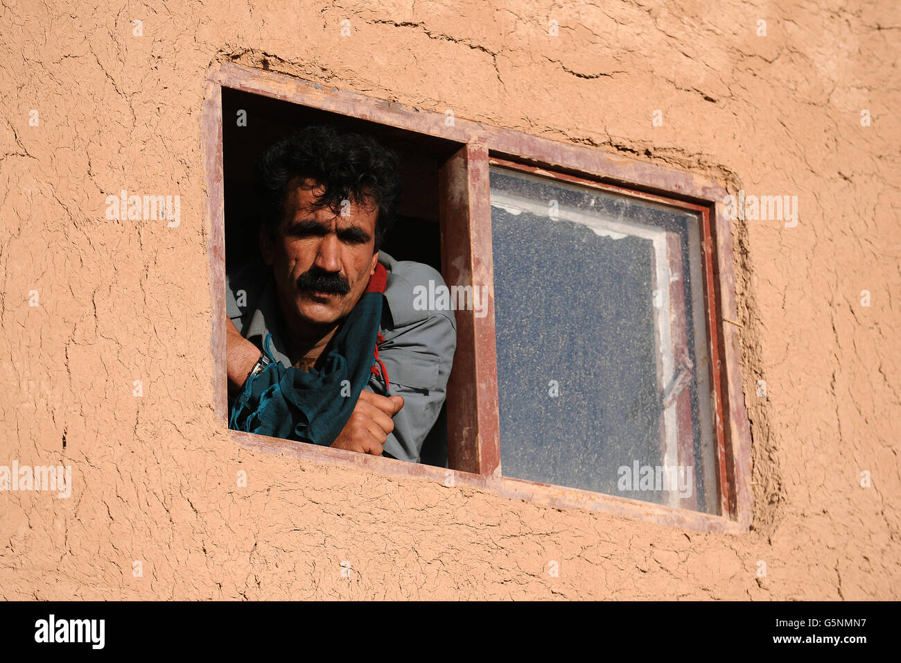 A member of the Afghan Local Police (ALP) looks out from checkpoint Chara-He, Helmand Province, Afghanistan Stock Photo