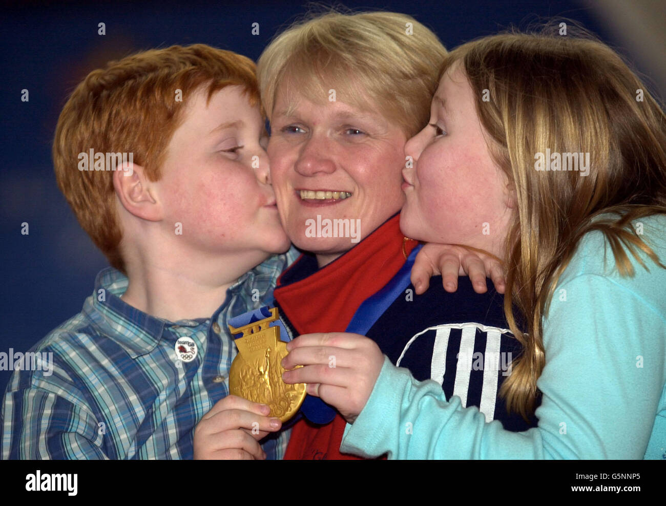 British curling skip Rhona Martin, displaying her Olympic gold gold medal, is kissed by son Andrew, six, and daughter Jennifer, nine, at the Greenacres Curling Club in Howwood. Stock Photo