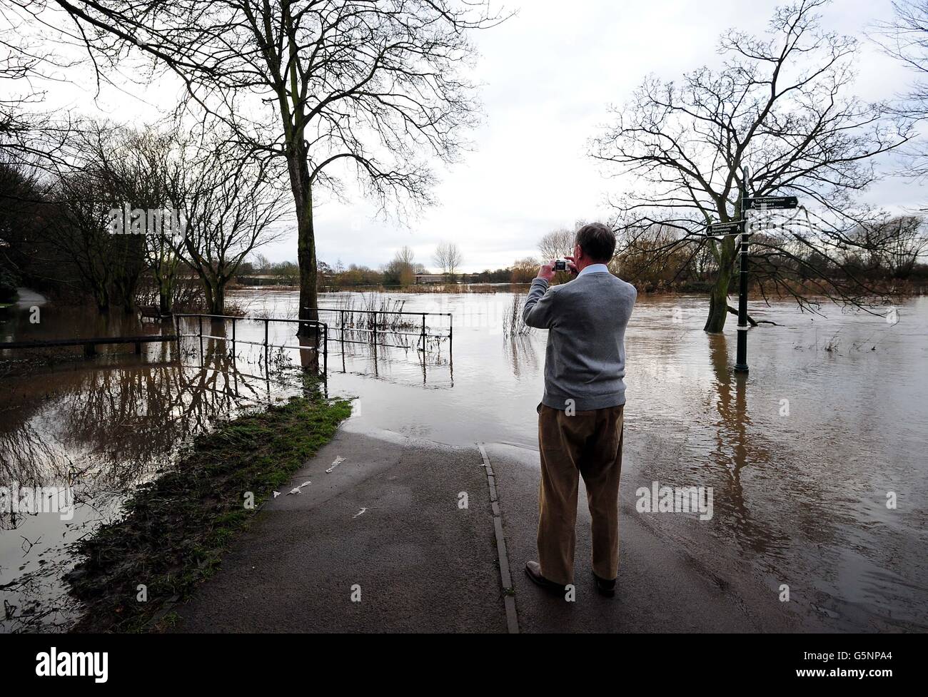 A man takes a photo of a flooded Washlands Park in Burton On Trent,  Staffordshire, as hopes of a white Christmas were washed out as many  Britons awoke to Yuletide flooding Stock