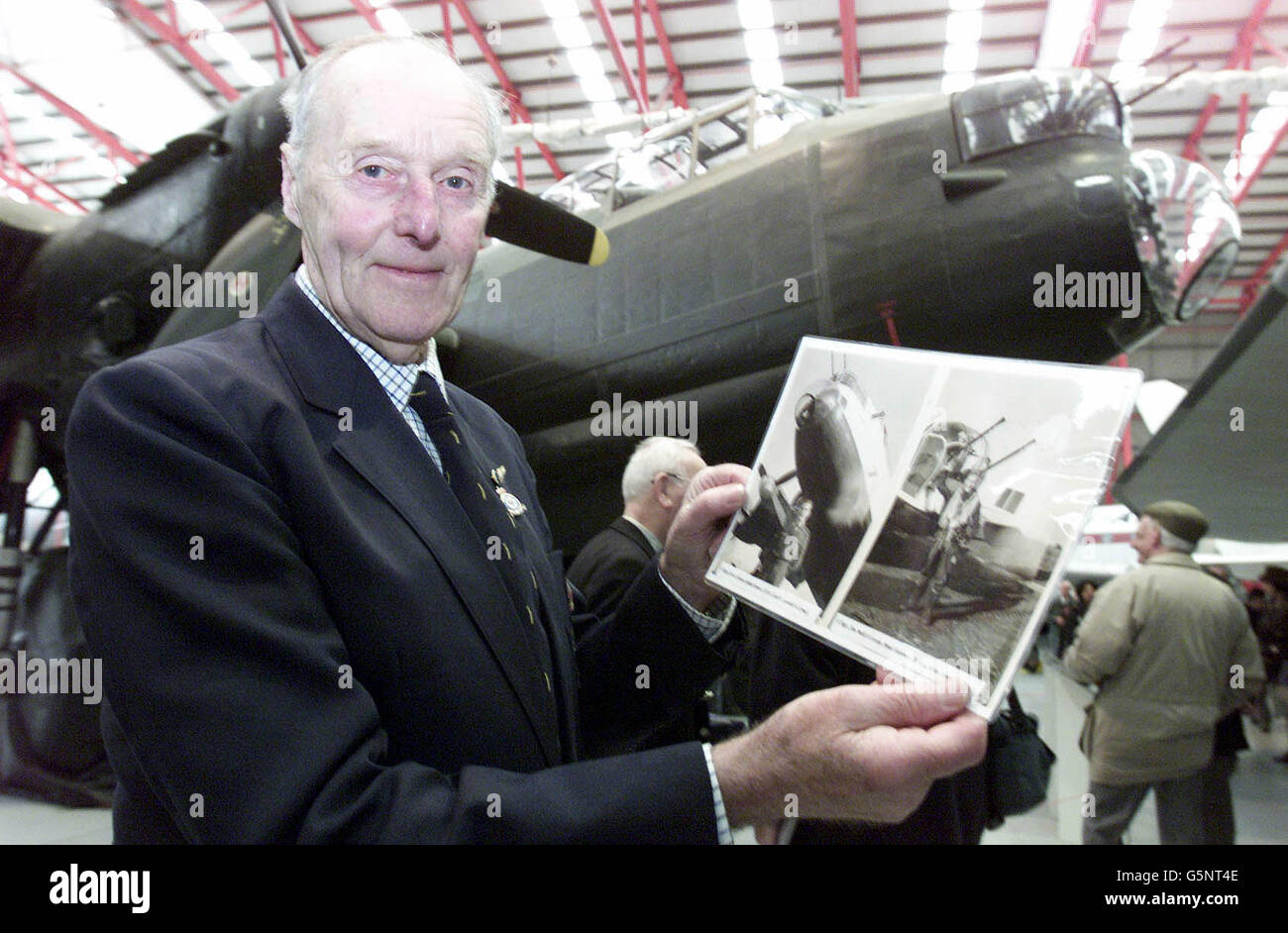 Jim McGillivray, Flight Sgt. in the 115 Squadron, with pictures of himself in front of a Lancaster during the war, during celebrations to mark the 60th anniversary of the plane's Second World War missions, at Duxford Air Museum, Cambridgeshire. * RAF veterans criticised the Ministry of Defence's failure to recognise the achievements of Bomber Command, feeling that campaign medals should have been awarded to the crews despite the controversy caused by the number of civilians killed during the bombing raids over Germany, which are seen as a vital contribution to the Allied victory. Stock Photo