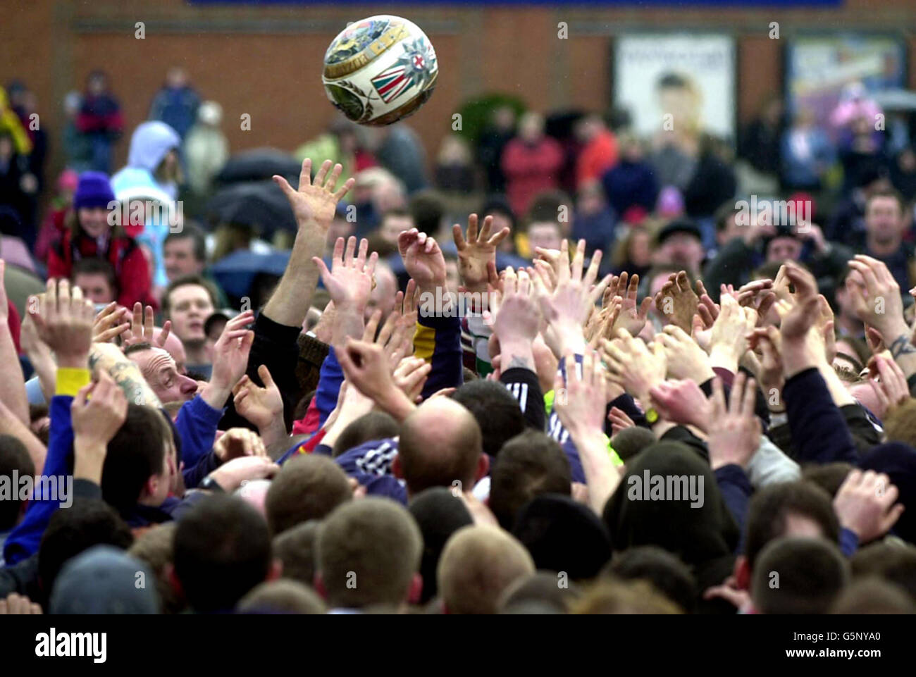 Residents from Ashbourne reach for the ball during the towns traditional Shrovetide football game at Ashbourne, Derbyshire. Shrovetide football dates back more than 800 years as a direct descendant of mediaeval mass football and is played between two sides. * ... - Up'ards, people born north of the river, and Down' ards, people born south of the river. Stock Photo