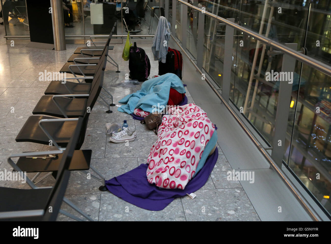 Passengers sleep as they prepare to depart from Terminal 5 at Heathrow ...