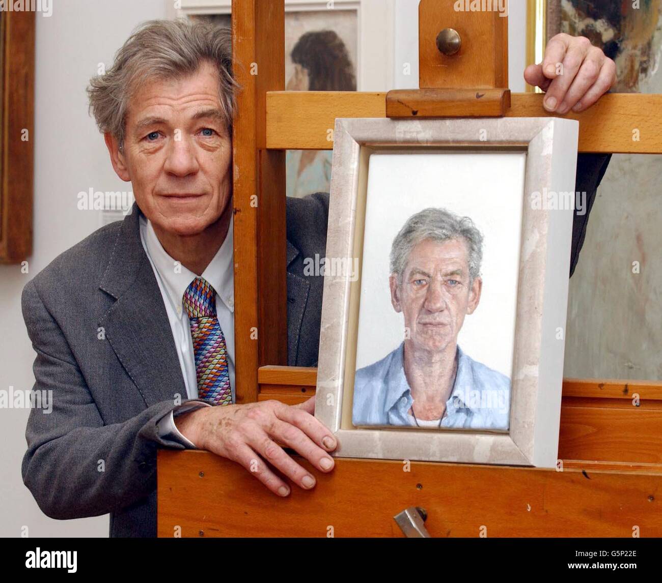 British actor Sir Ian McKellen with a new portrait of himself by Clive Smith during a photocall at the National Portrait Gallery. The work will go on public display from Wednesday 27 February 2002. The work has been commissioned by the National Portrait Gallery, * from the artist, who is a previous winner of the BP Portrait Award, as part of this prize. Stock Photo
