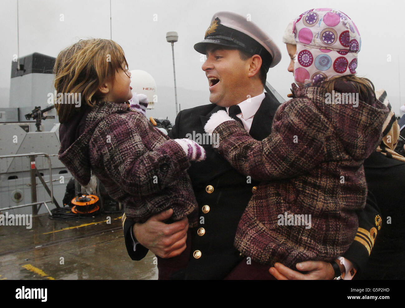 Lieutenant Commander Tim Davey, Commanding Officer of HMS Blyth, is welcomed home by his daughters Lauren Davey and Ellen Davey at HM Naval Base on the Clyde. Stock Photo