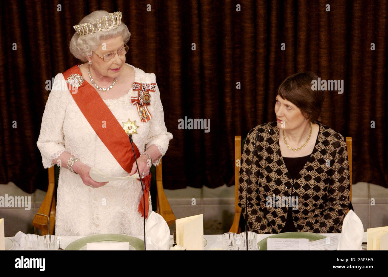 Britain's Queen Elizabeth II (left) stands next to New Zealand Prime Minister Helen Clark as she addresses a State Dinner at Parliament House, Wellington, New Zealand, during a visit to the country. * The Queen said it had been a privilege and a pleasure to serve as the country's head of state for the past 50 years and said she looked foreword to continuing to serve to the best of her ability in the years to come. Stock Photo