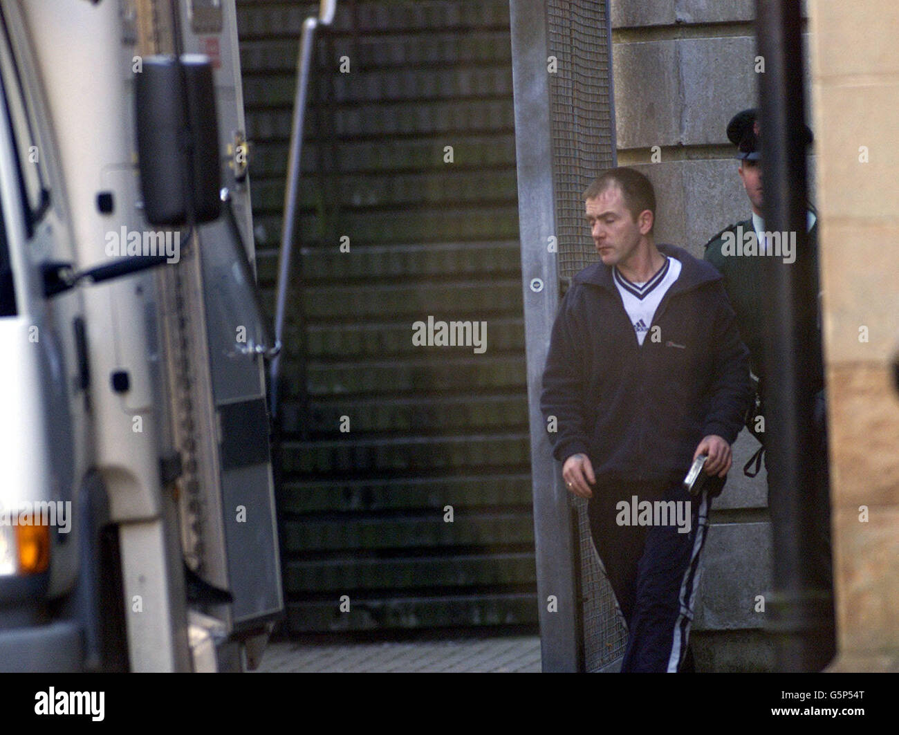 David (Eggy) Mooney is escorted to a prison van at Ballymena Court house. Mooney was one of eighteen people arrested yesterday in a province-wide swoop by police tarketing heroin users and dealers. He was remanded into police custody with four other men. Stock Photo