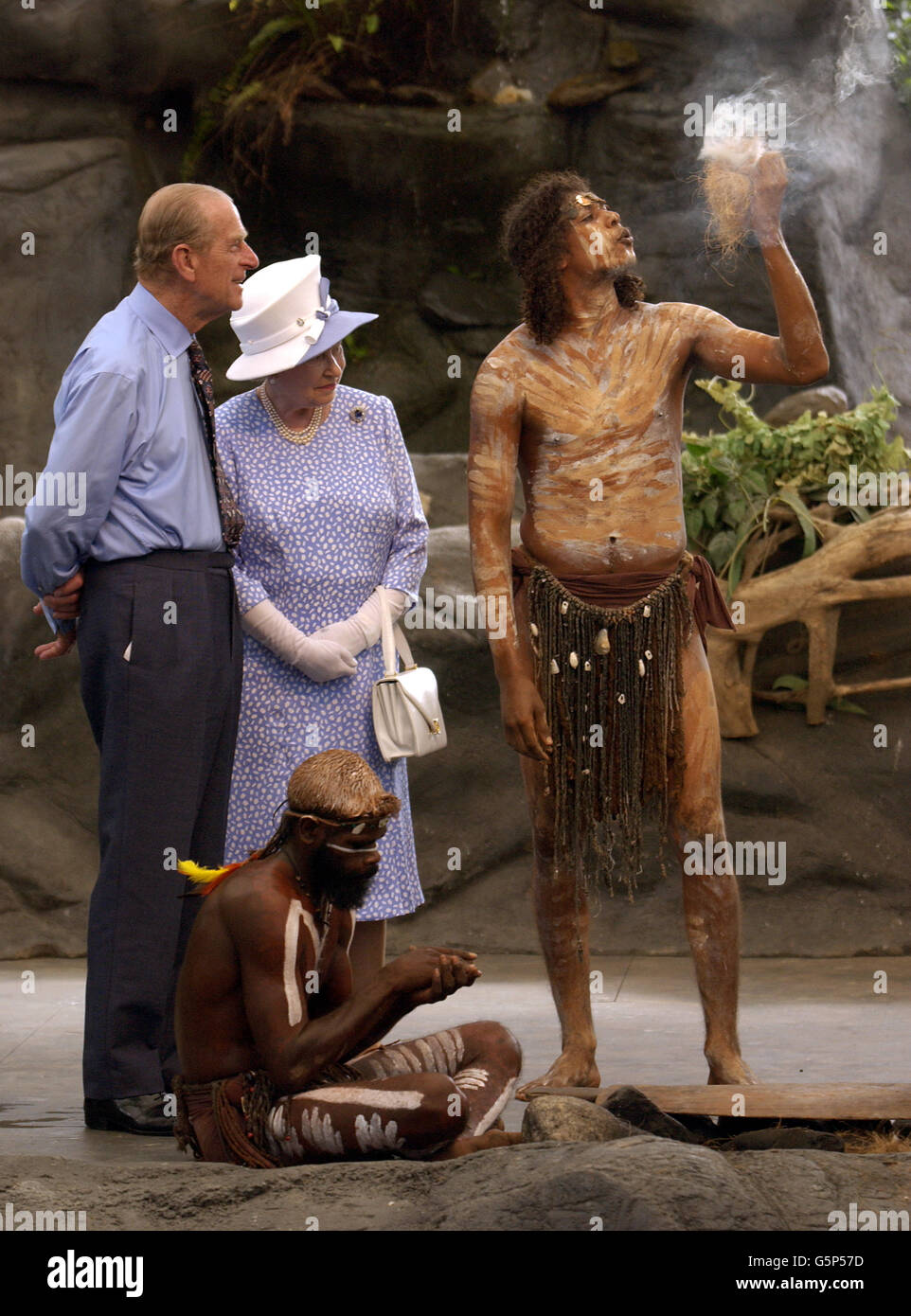 Britain's Queen Elizabeth II and the Duke of Edinburgh watching a culture show at Tjapukai Aboriginal Culture Park, Cairns, Australia Friday. The Duke surprised the aborigines when he asked them 'Do you still throw spears at each other?' *The Royal couple watched a performance by the Tjapukai dance troop of nine Aboriginal male dancers in loin cloths and wearing body paint, and a didgeridoo player. Stock Photo