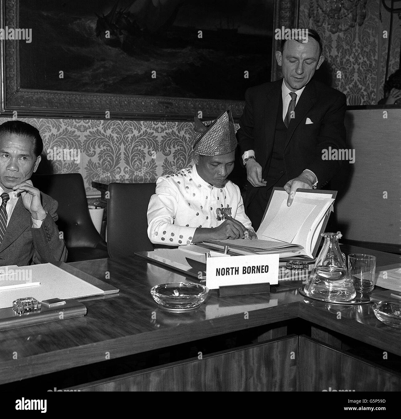 O.K.K. Datu Mustapha, one of the North Borneo delegates, is pictured signing the agreement setting up the Federation of Malaysia at Marlbrough House in London. Stock Photo