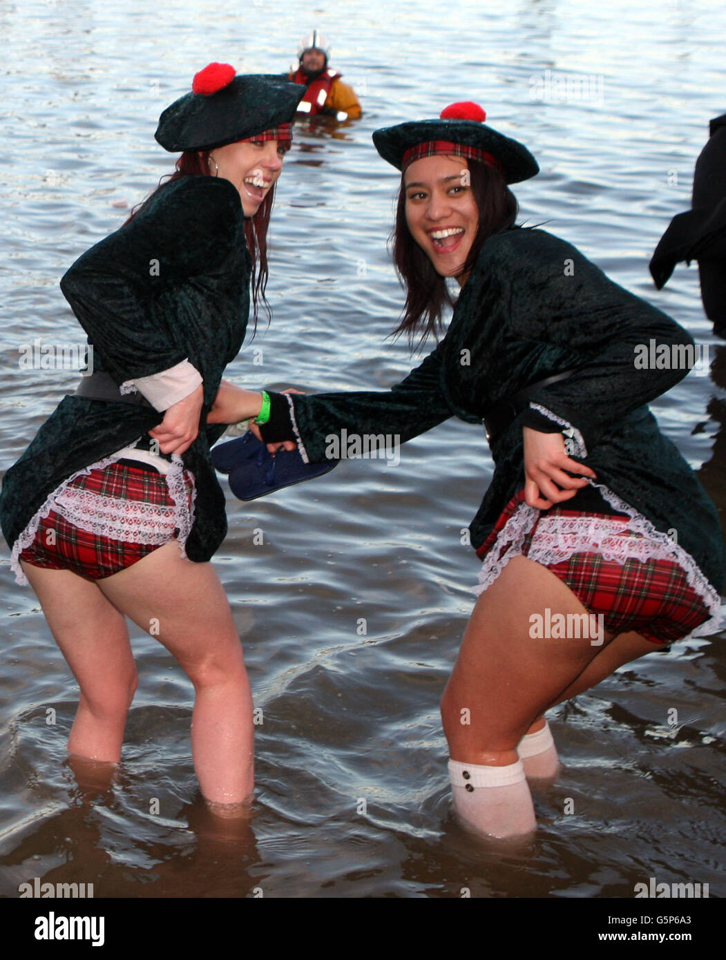 Swimmers take part in the Loony Dook New Year's Day swim in the river Forth near the Forth Rail Bridge. Stock Photo