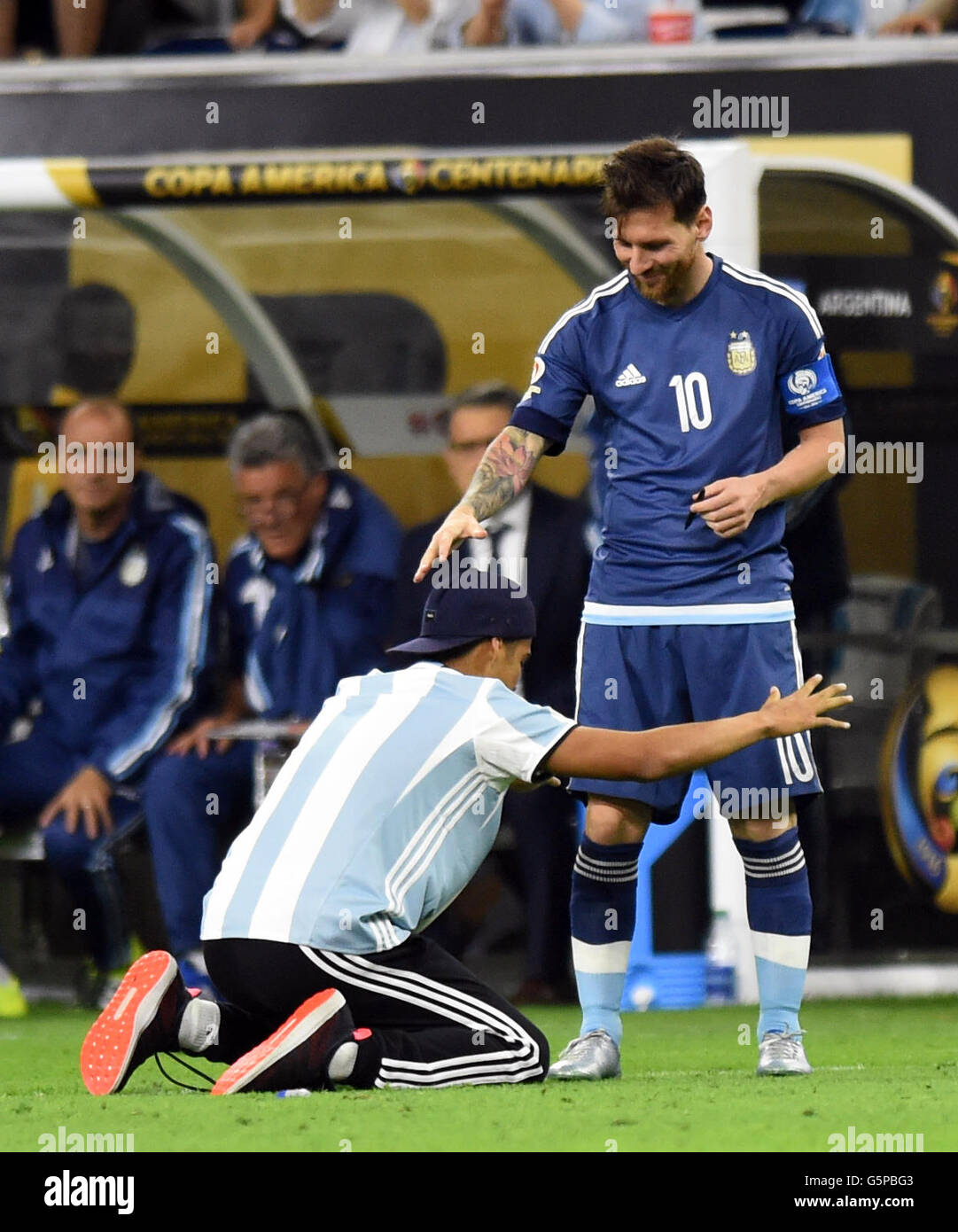 Houston, USA. 21st June, 2016. A fan (L) of Argentina's Lionel Messi gets onto the field to greet him before the start of the second half the semifinal match of 2016 Copa