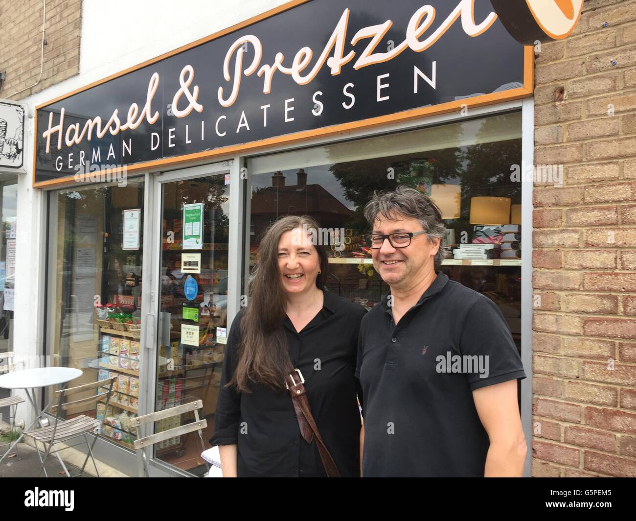 Petra Braun (L) and Peter Wengerodt stand in front of their German gourmet food shop 'Hansel & Pretzel' in the district of Richmond in London, Great Britain. In their German specialities shop, the two also sell 'Europeans, ' a variation of black and white cookie known as an 'American' in Germany. They are using the cookie to alert their customers to the fact that they depend on the currency exchange between the euro and pound. The 'European' is 20 cents more than a normal 'American.' If the pound loses value in the case of a Brexit, then they will have to buy their products at a higher price i Stock Photo