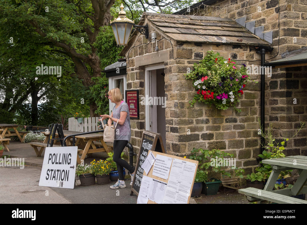 The Hermit, a village pub in Burley Woodhead, West Yorkshire, Britain. 23rd June, 2016. Having cast her vote, a voter leaves this EU Referendum Polling Station. Credit:  Ian Lamond/Alamy Live News Stock Photo