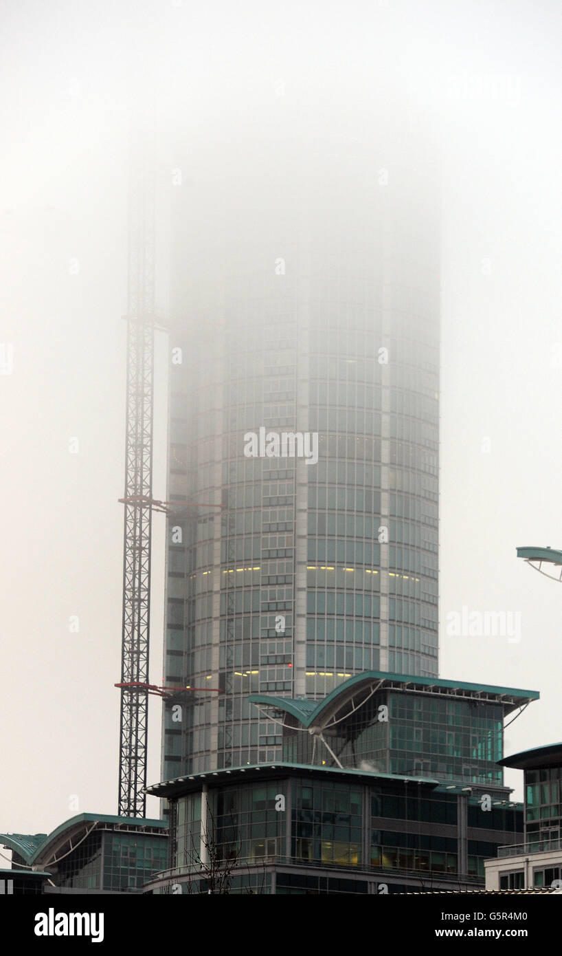 The mist shrouded top of St George's Wharf tower building, where a Helicopter crashed into this morning, in Vauxhall south London. Stock Photo