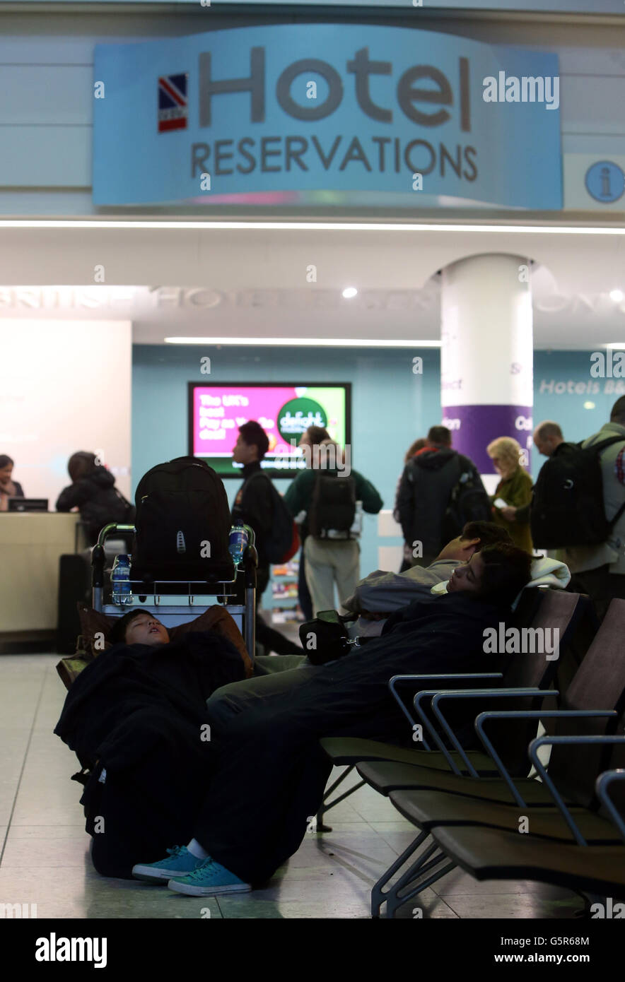 Stranded passengers sleep in the arrivals hall at Terminal 5 at
