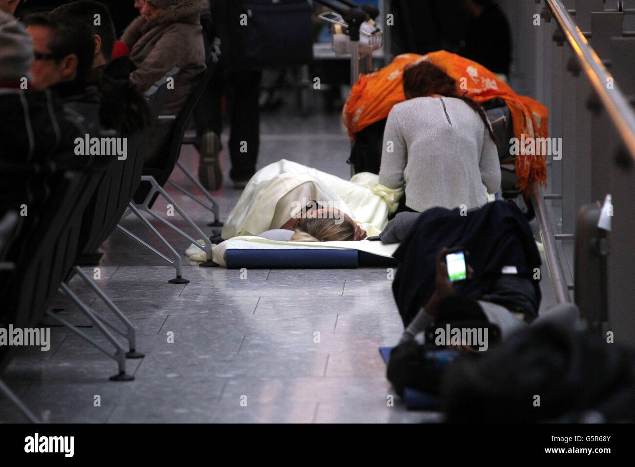 Stranded passengers sleep in the departures hall at Terminal 5 at