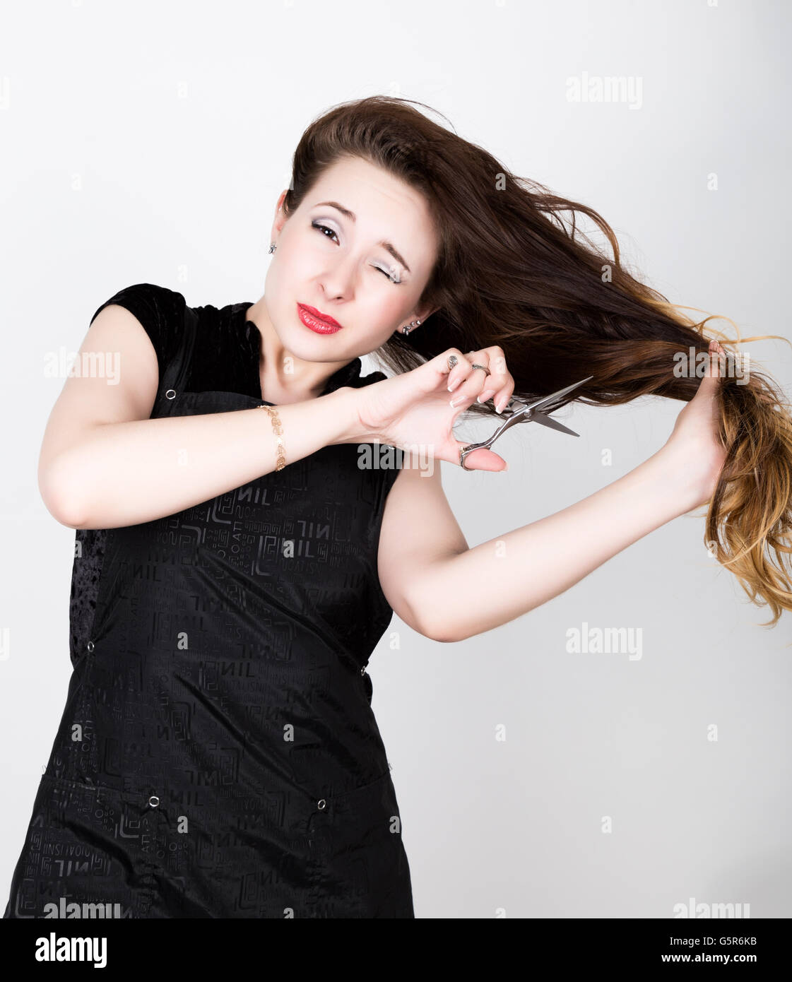 female Hairdresser trying to cut your own hair with scissors Stock