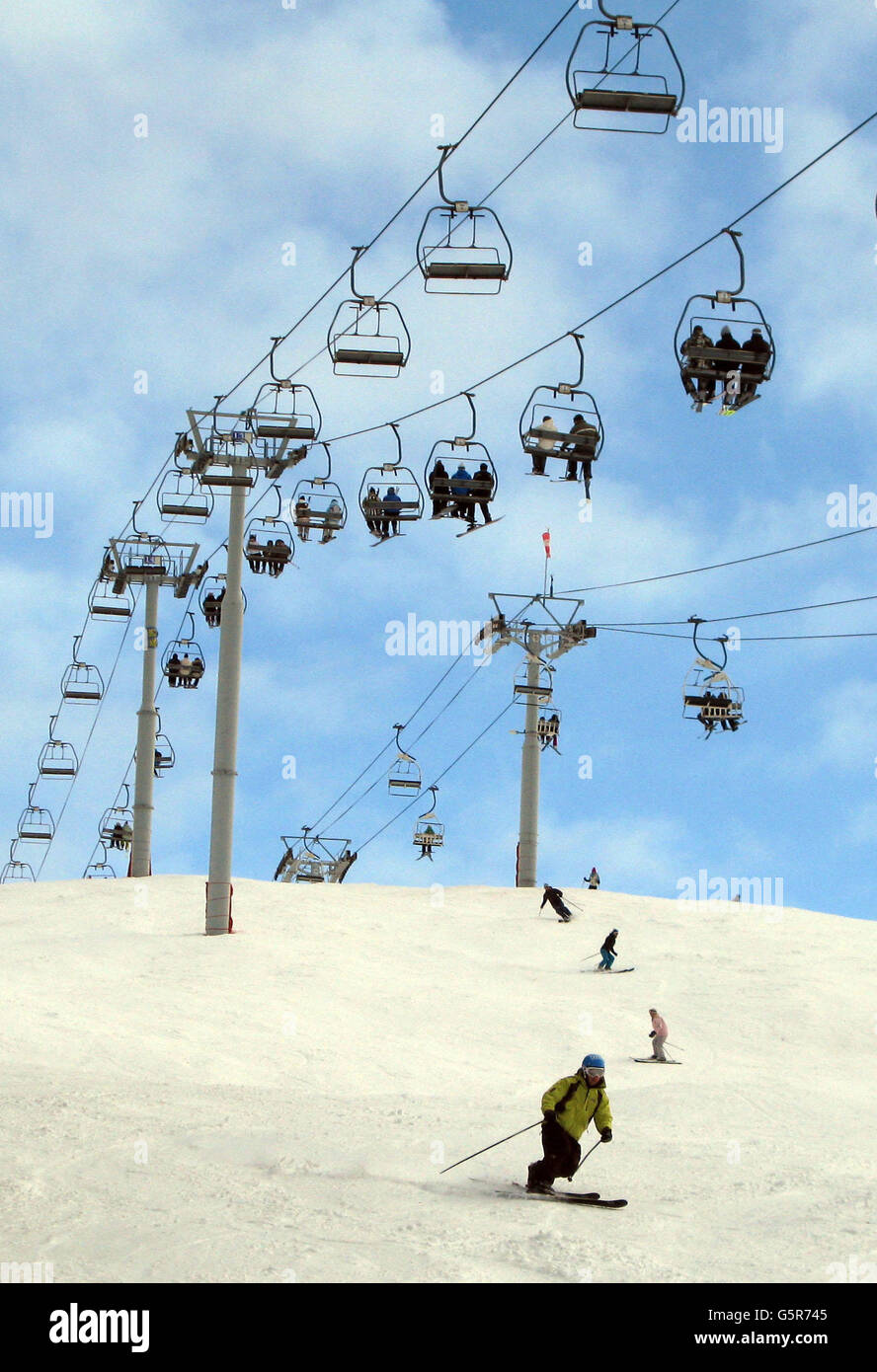 Skiing on the De L'aiguille mountain over La Clusaz. The La Clusaz ski and snow sports area in France is over five mountains and eighty four slopes with a top altitude of 2600m . Stock Photo