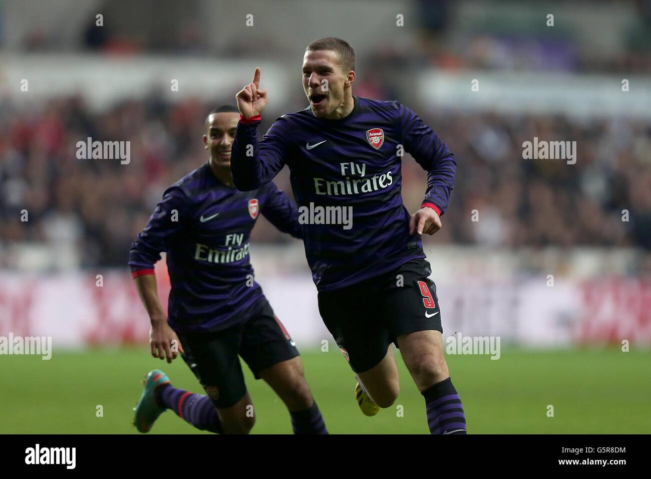Arsenal's Lukas Podolski (right) celebrates with team-mates Santi Cazorla  (centre) and Mikel Arteta after scoring his side's second goal of the game  Stock Photo - Alamy, image size:1300x956