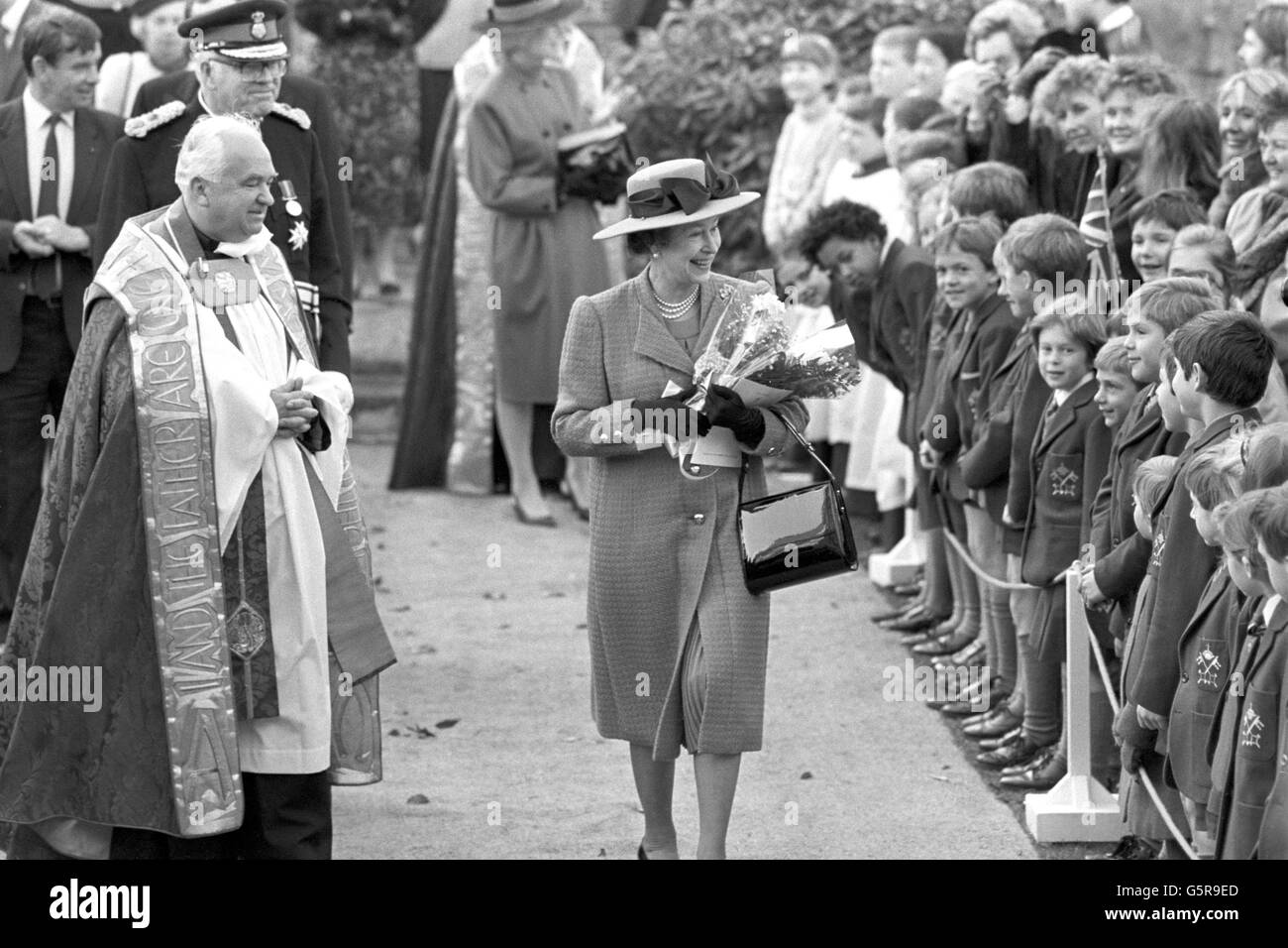 The Queen walks past children from the Minster School in the garden of the Treasurer's House at York Minster, following a service of rededication for the 700-year-old south transept, which was restored following a fire four years ago. Stock Photo