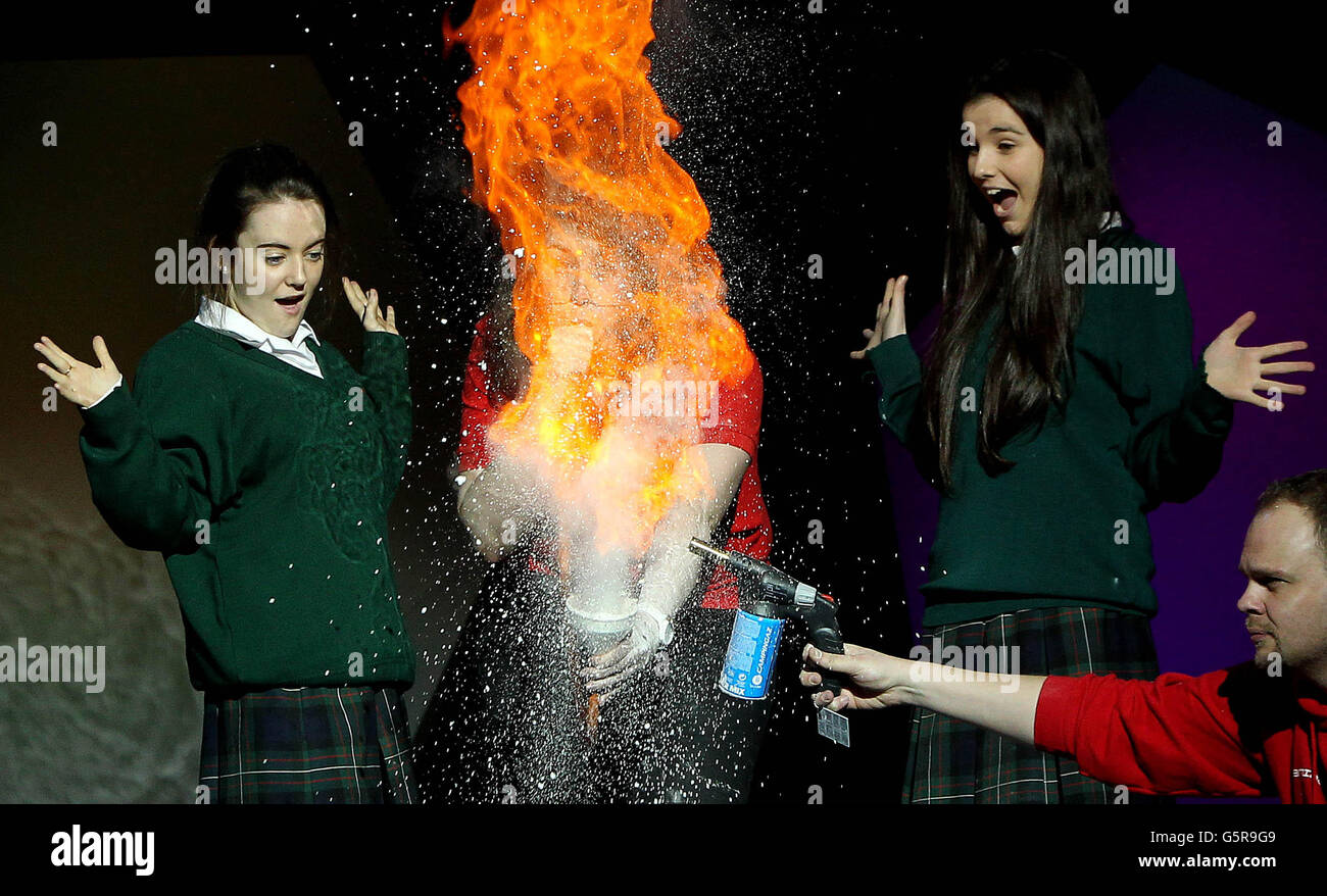 (left to right) Saoirse O'Reilly and Naoise O'Driscoll from Loreto High School watch as Laura Meade and Ronan Bullar from the Science Museum in London set fire to baking soda at the launch of the 49th BT Young Scientist & Technology Exhibition in the RDS in Dublin today. Stock Photo
