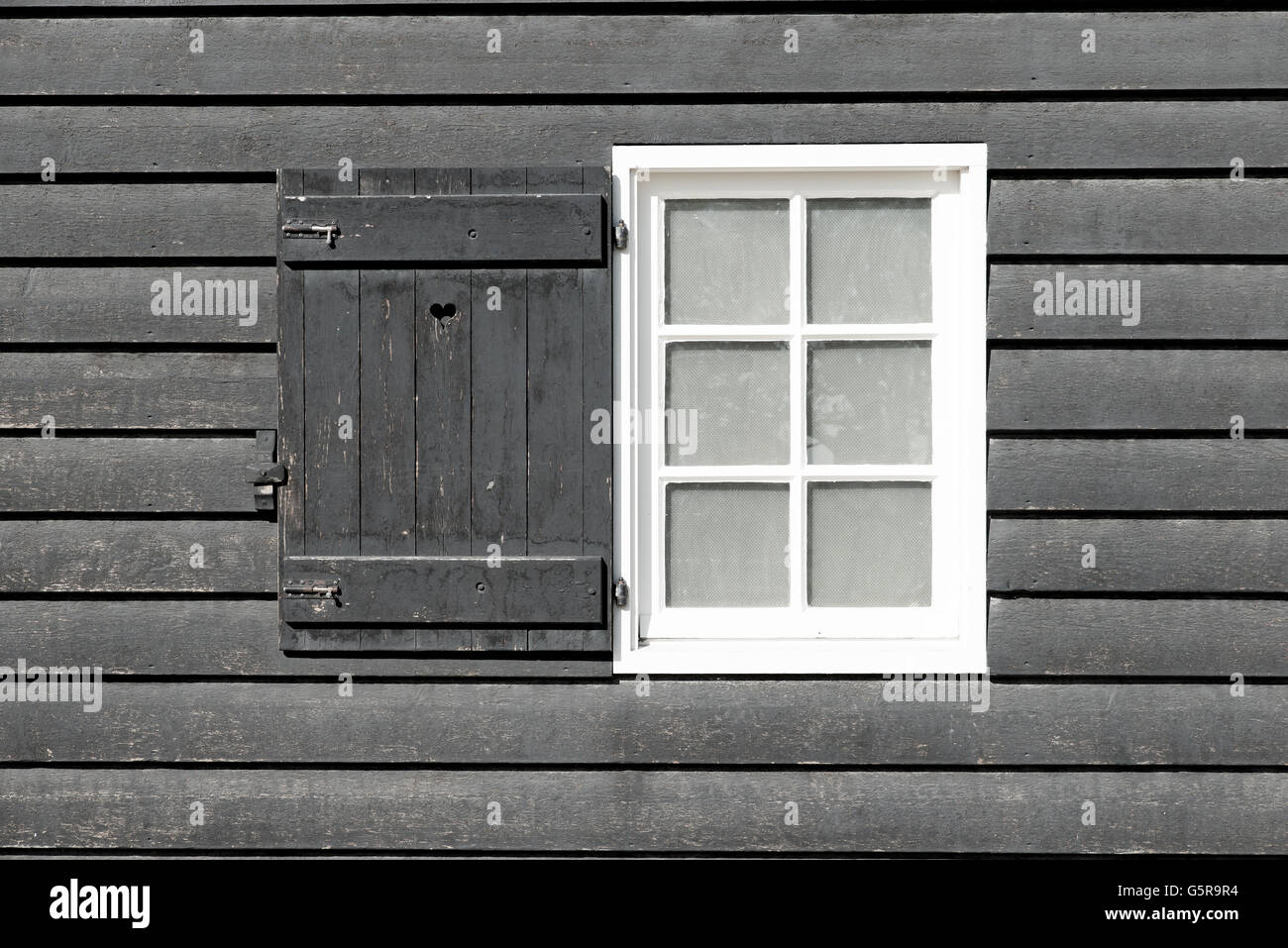 Black old wood window in country house. White window on black wooden wall. Window is open. Stock Photo