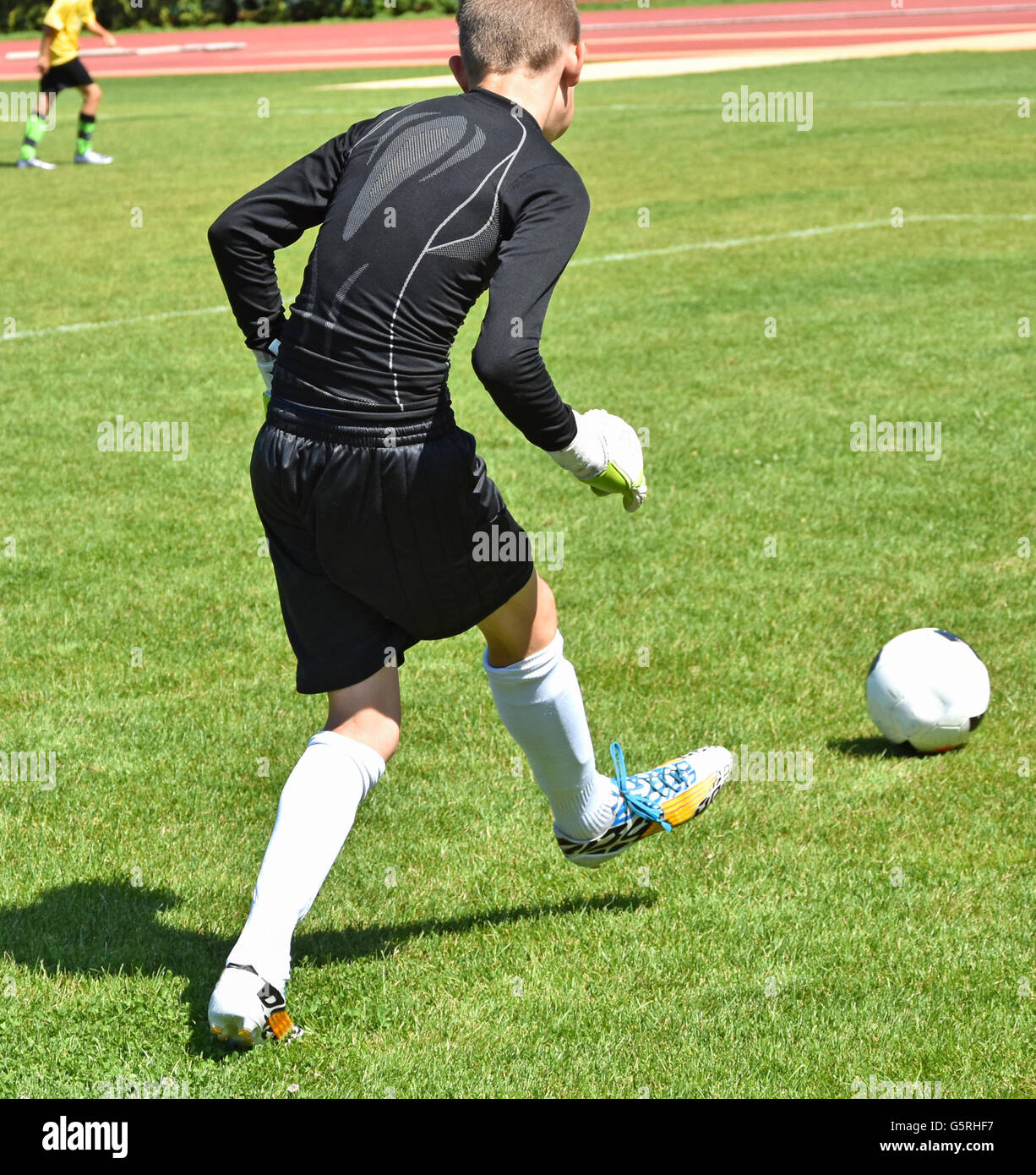 Young goalkeeper kicks the ball off Stock Photo