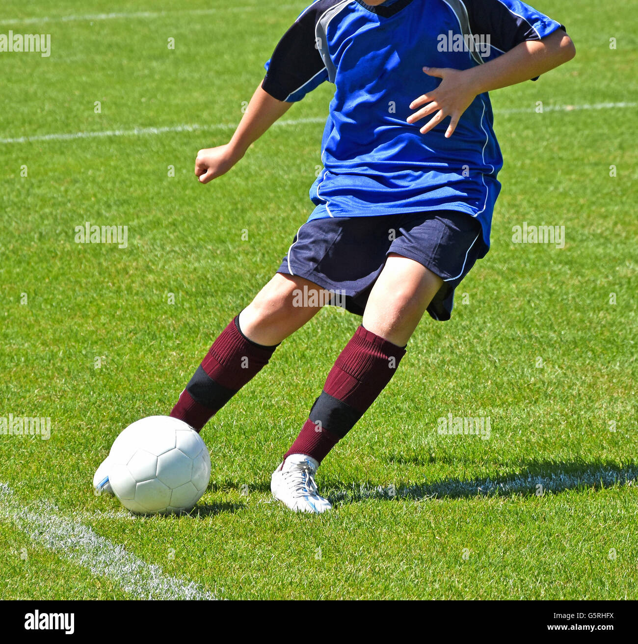 Young child kicks the ball Stock Photo