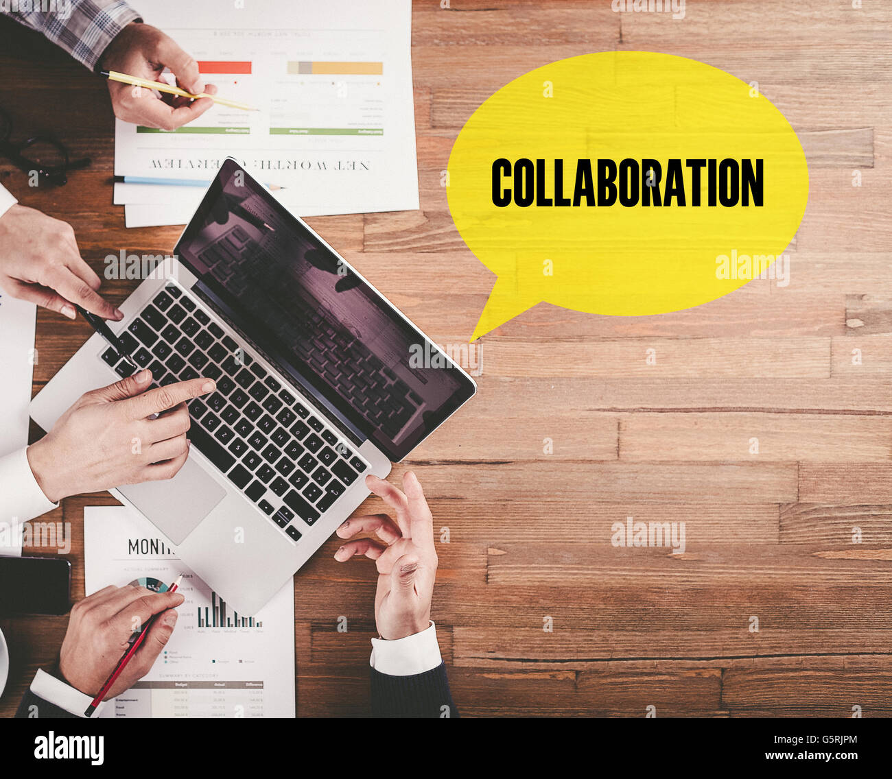 BUSINESS TEAM WORKING IN OFFICE WITH COLLABORATION SPEECH BUBBLE ON DESK Stock Photo