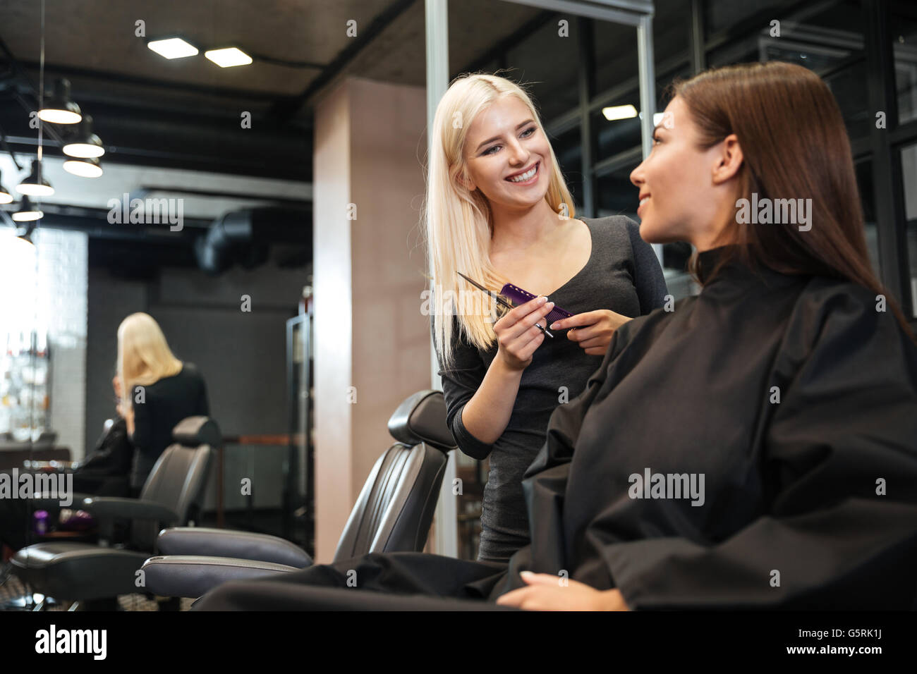 Woman Hair Stylist Making Hairdo To Attractive Young Girl With